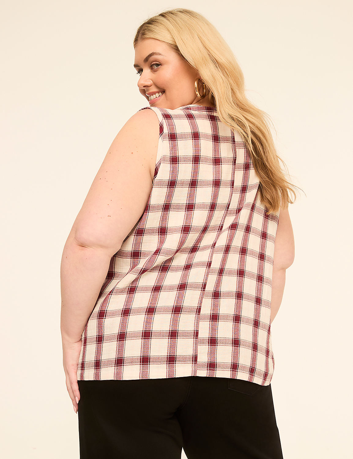A woman in a plaid top and black pants smiles over her shoulder against a plain background. Product Image 2