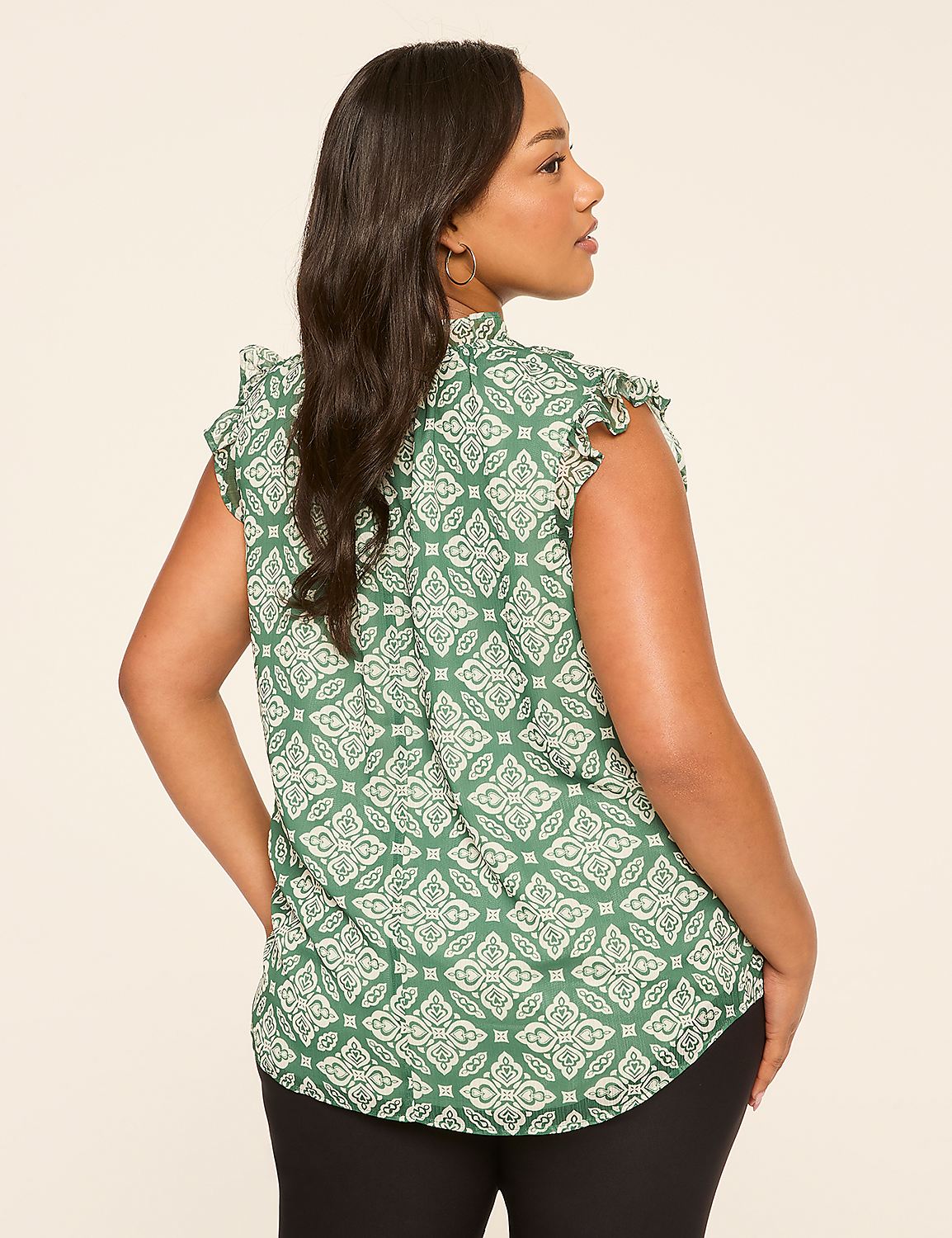 A woman in a green patterned blouse stands against a plain, light-colored background. Product Image 2