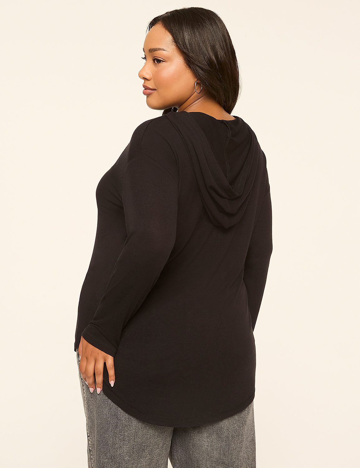 A woman in a black hooded shirt and gray jeans stands against a plain, light-colored background. Product Image 2