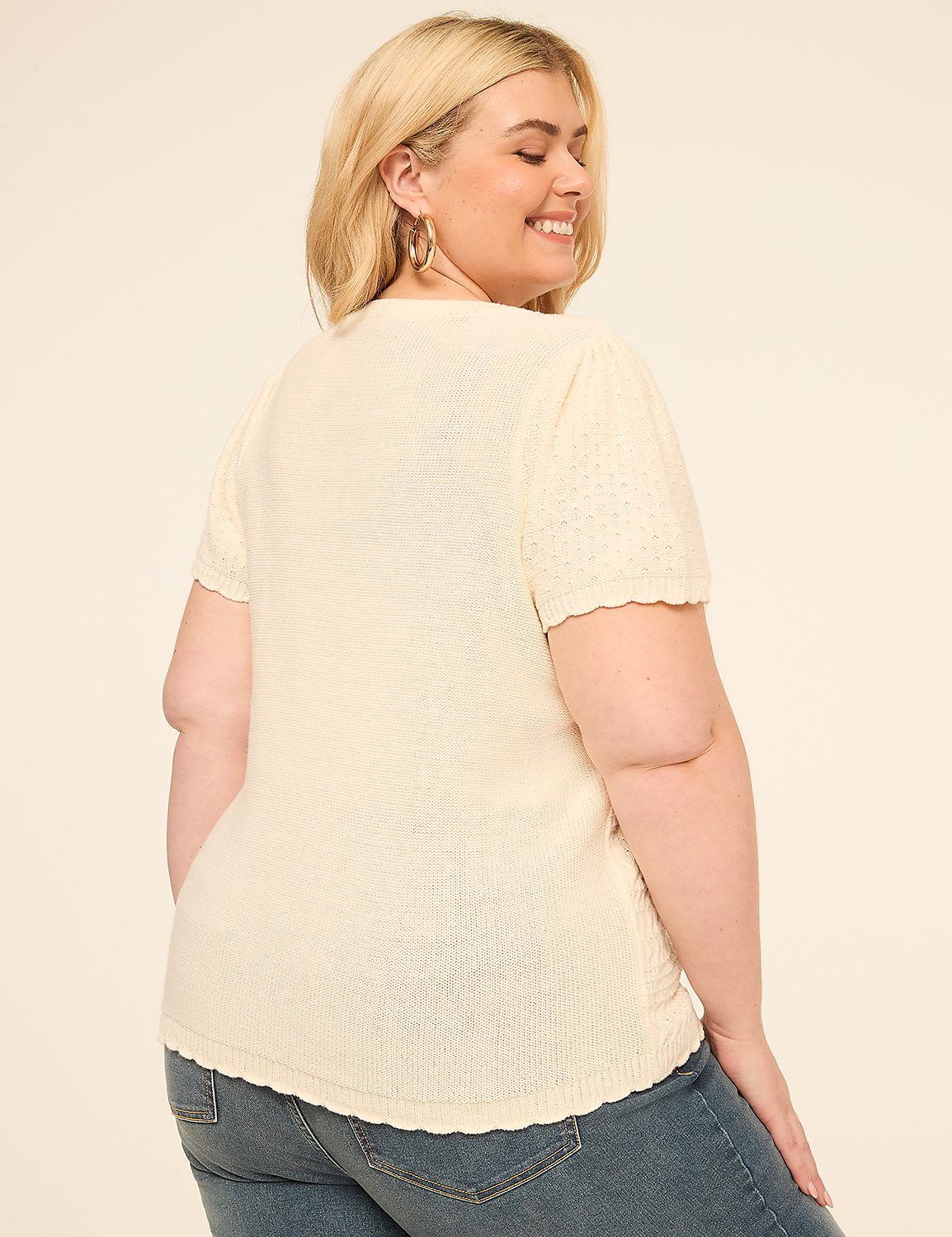 A woman in a cream-colored top and blue jeans stands against a plain beige background. Product Image 2