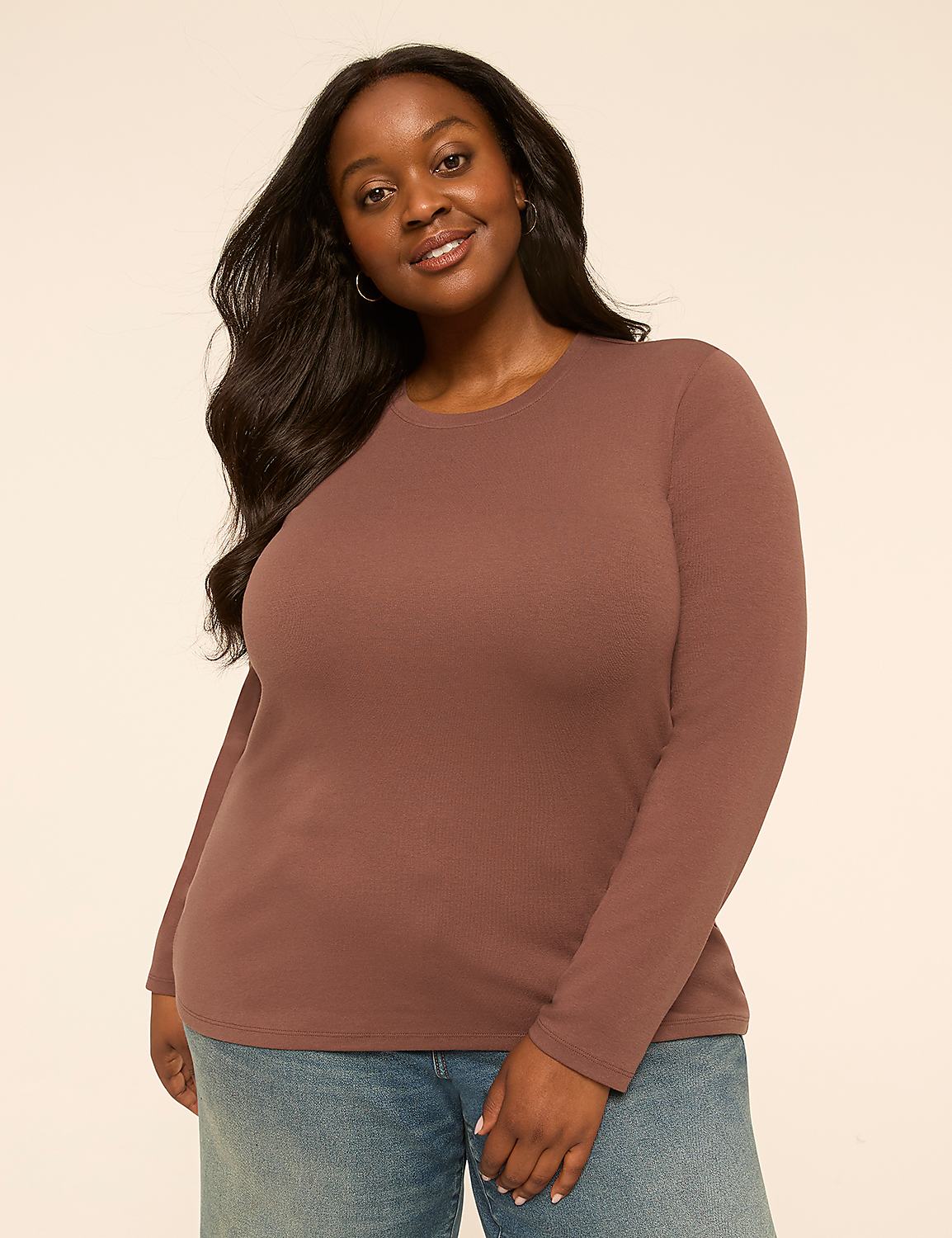 A smiling woman with long dark hair wears a brown long-sleeved shirt and blue jeans against a plain, light-colored background. Product Image 1