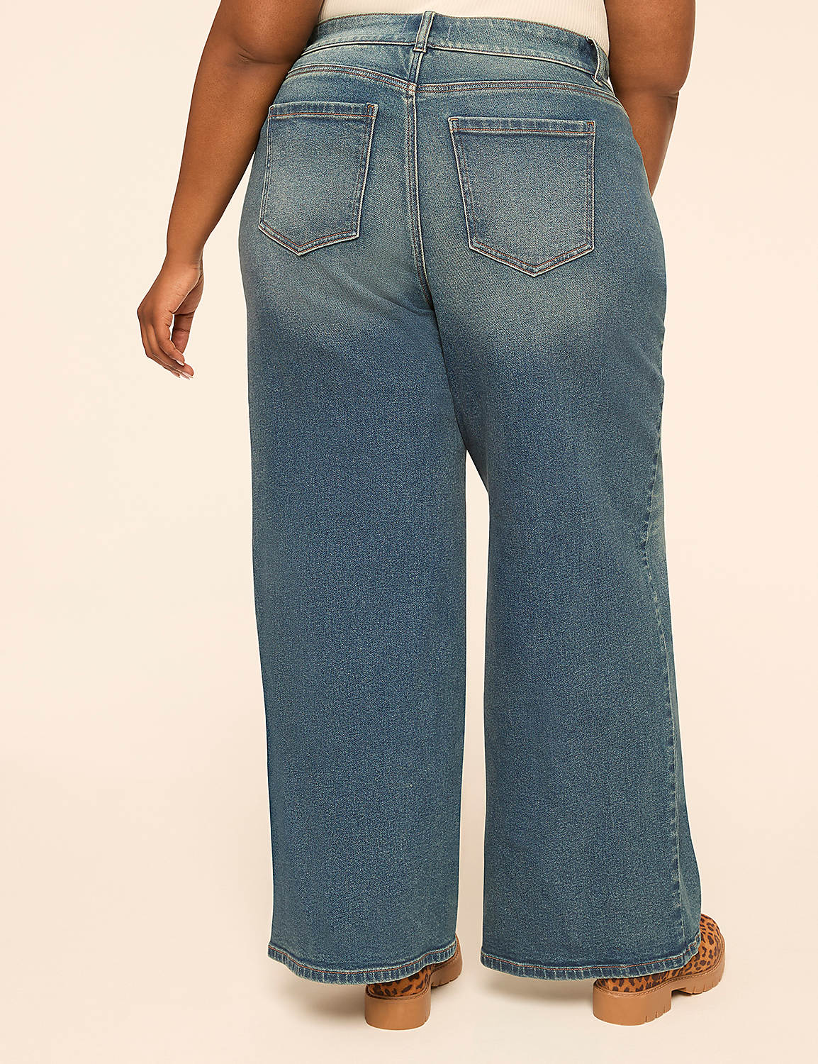 A person wearing wide-leg blue jeans and leopard print shoes stands against a plain, light-colored background. Product Image 2