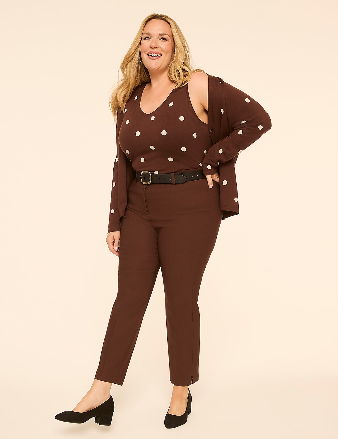 A smiling woman in a brown polka dot outfit stands against a plain, light-colored background. Product Image 3