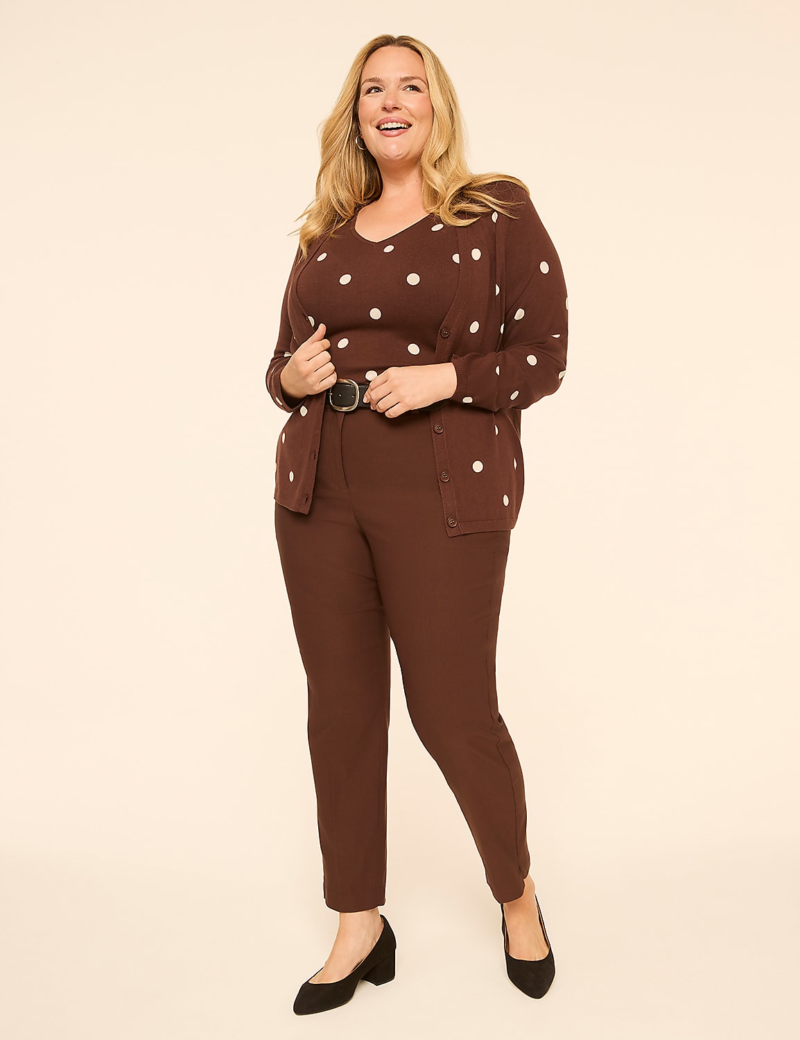 A smiling woman in a brown polka dot cardigan and matching pants stands against a plain, light brown background. Product Image 3