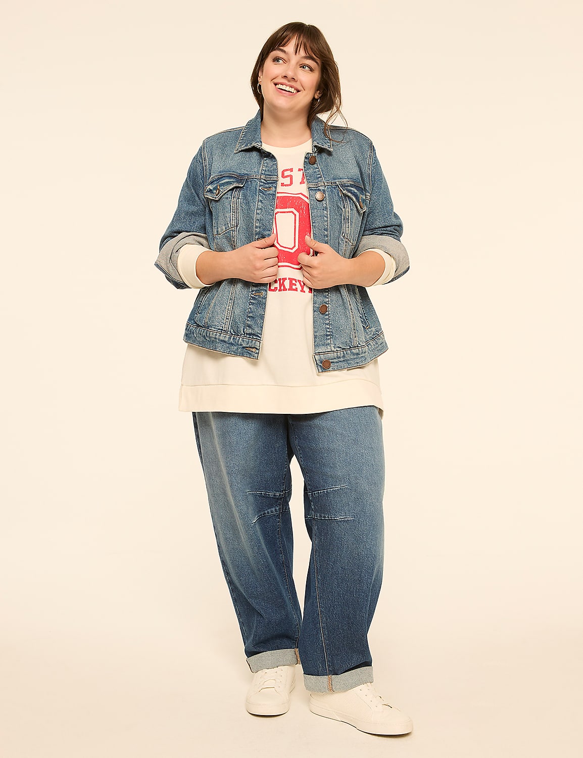 A smiling woman in a denim jacket and loose jeans stands against a plain, light-colored background. Product Image 3