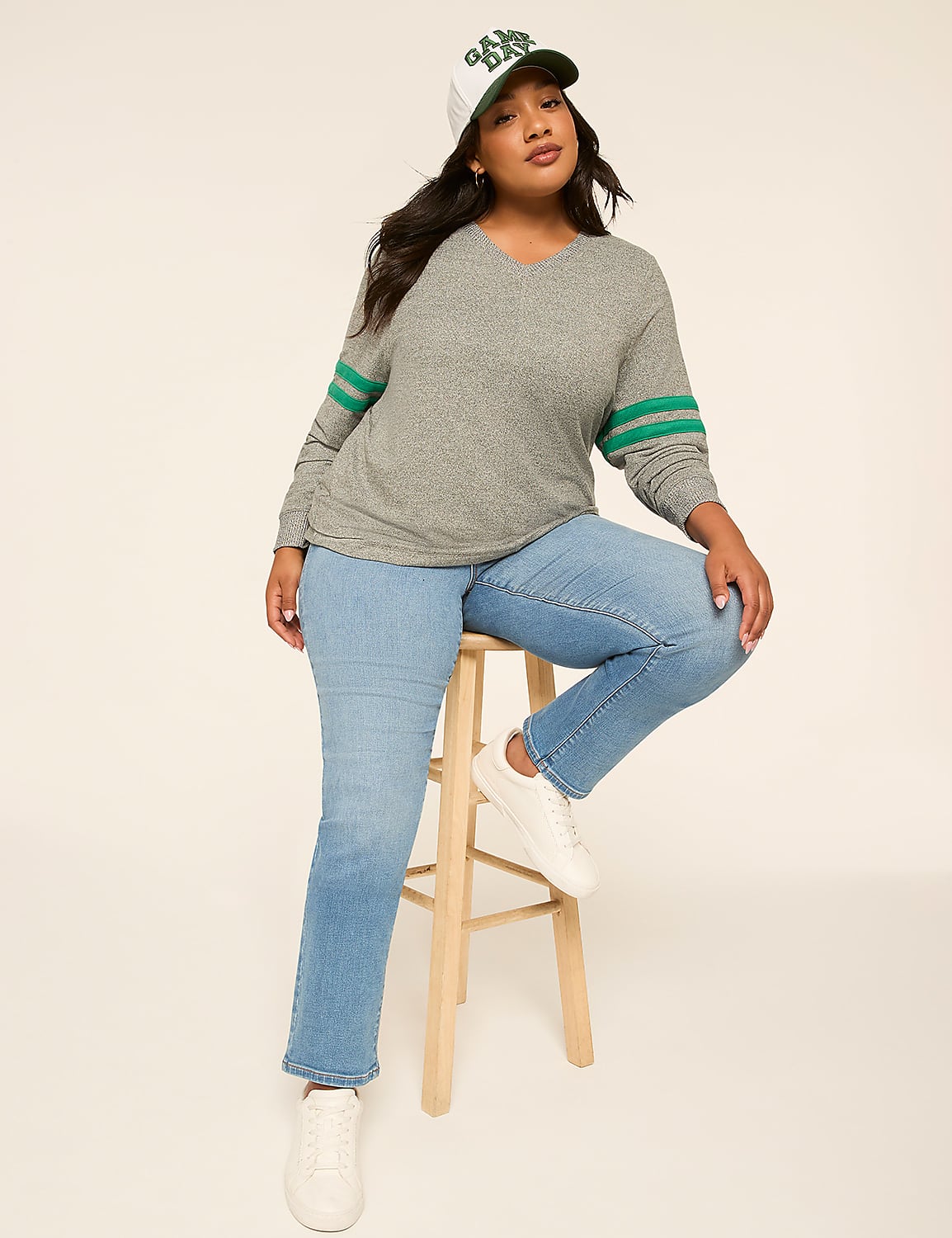 A woman in a gray sweater and jeans sits on a stool against a plain, light-colored background. Product Image 3