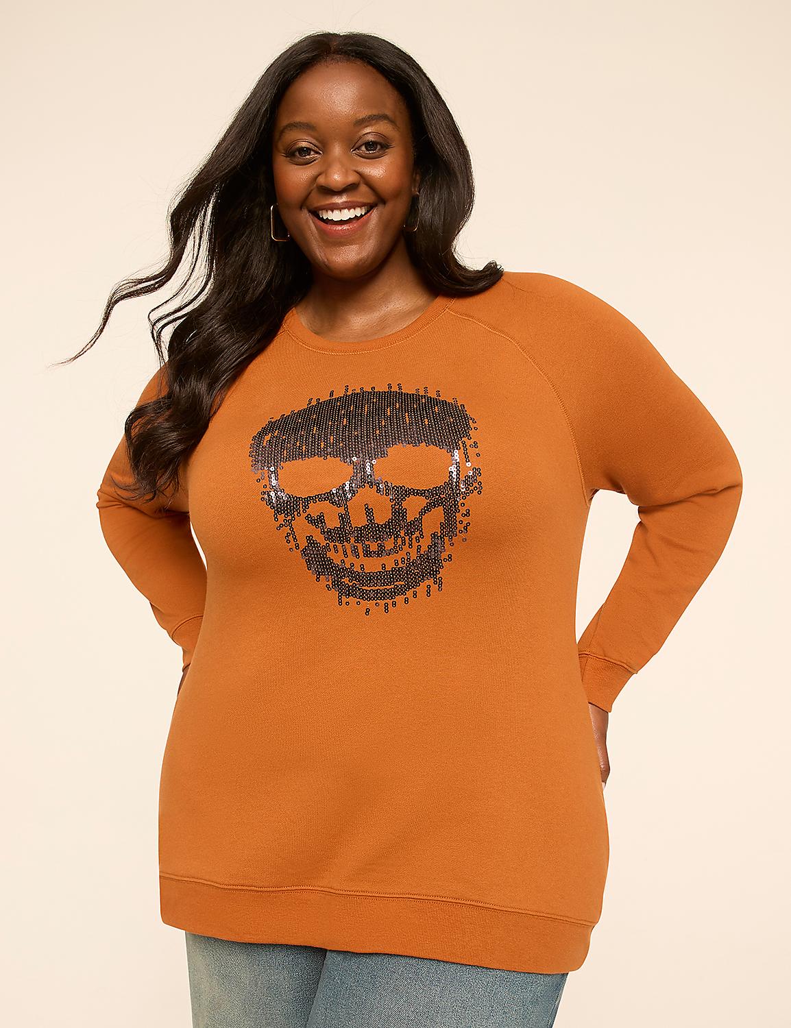 A smiling woman in a burnt orange sweatshirt with a sequined skull design stands against a plain, light background. Product Image 1
