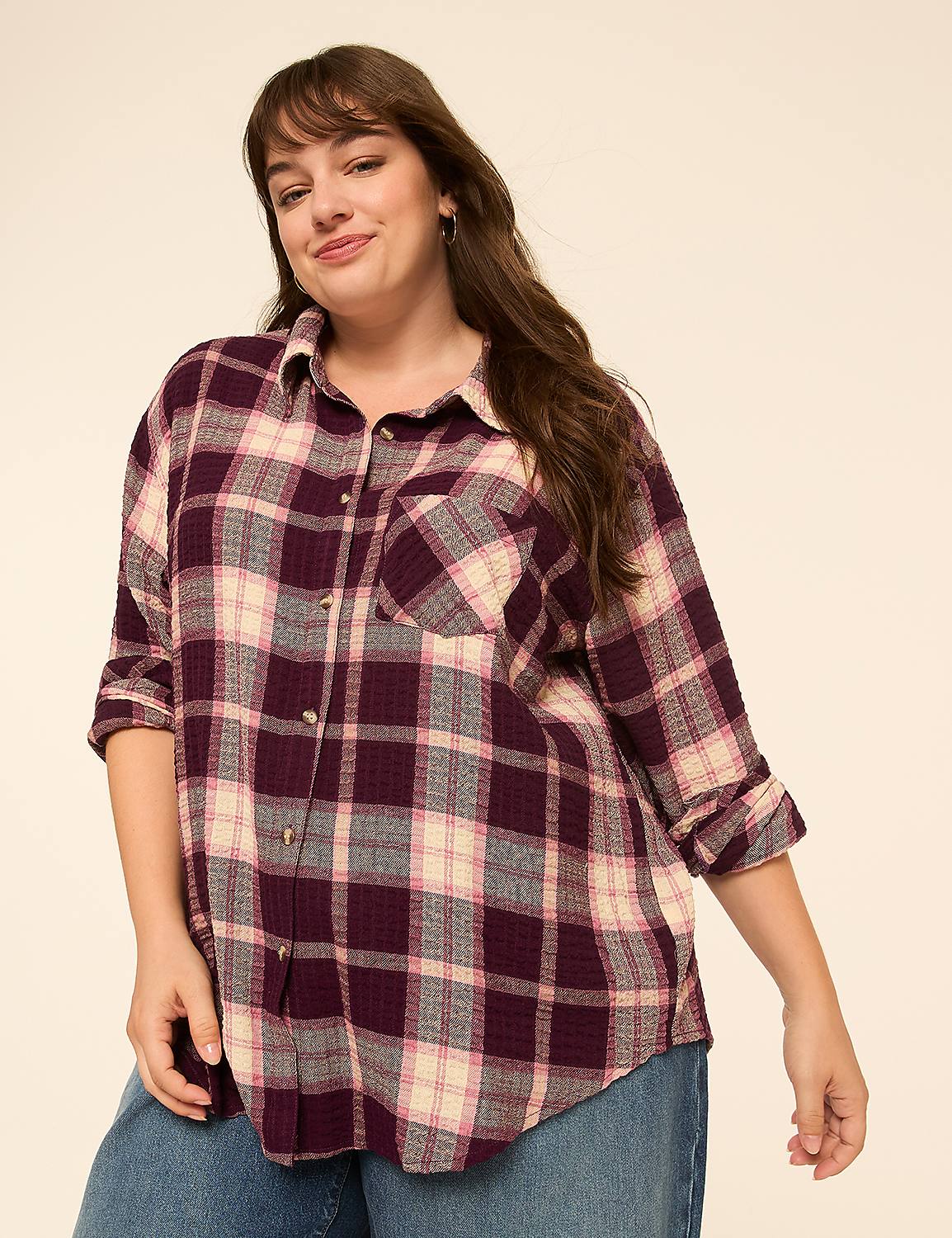 A woman in a burgundy and cream plaid shirt stands against a plain, light background. Product Image 1