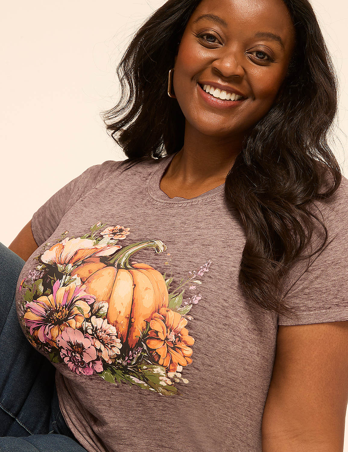 A smiling woman in a t-shirt with a pumpkin and floral design is shown against a plain background. Product Image 4
