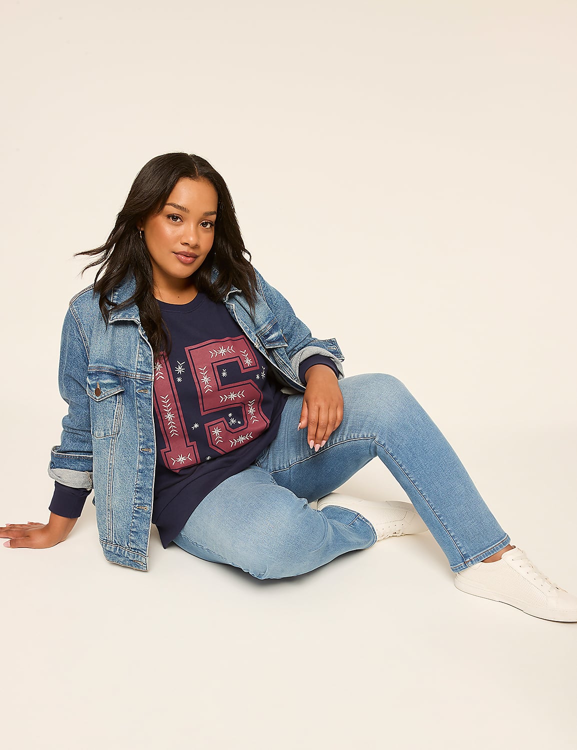 A woman in a denim jacket and jeans sits on a plain background. Product Image 3