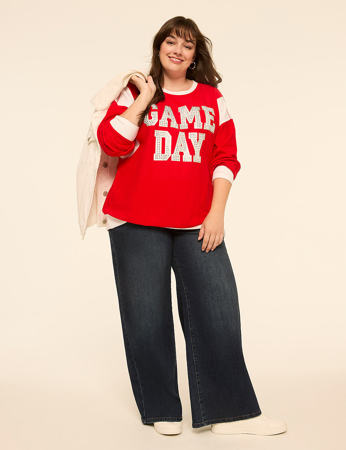 A smiling woman in a red "GAME DAY" sweatshirt and wide-leg jeans stands against a plain, light-colored background. Product Image 3