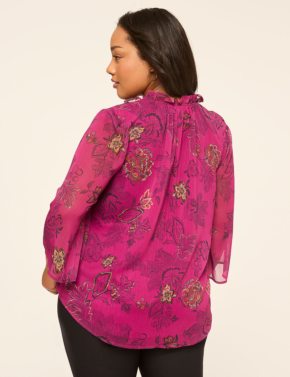 A woman in a floral print pink blouse stands against a plain, light-colored background. Product Image 2
