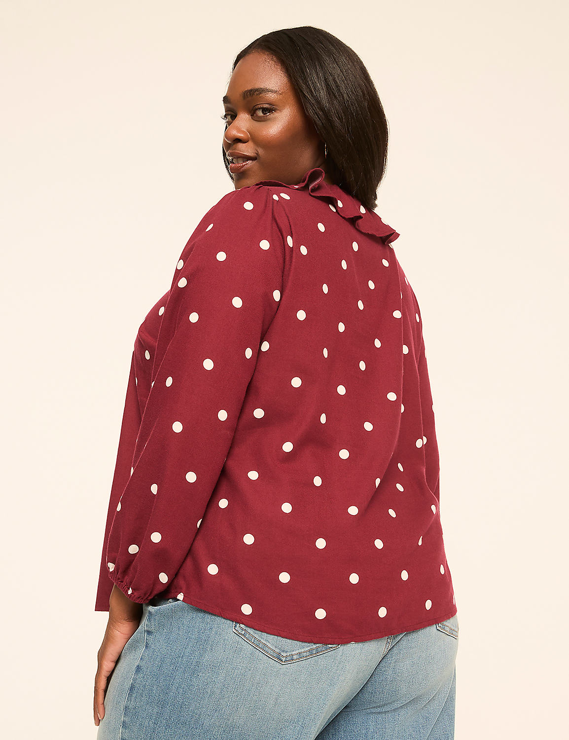 A woman in a maroon polka dot blouse and jeans stands against a plain, light-colored background. Product Image 2