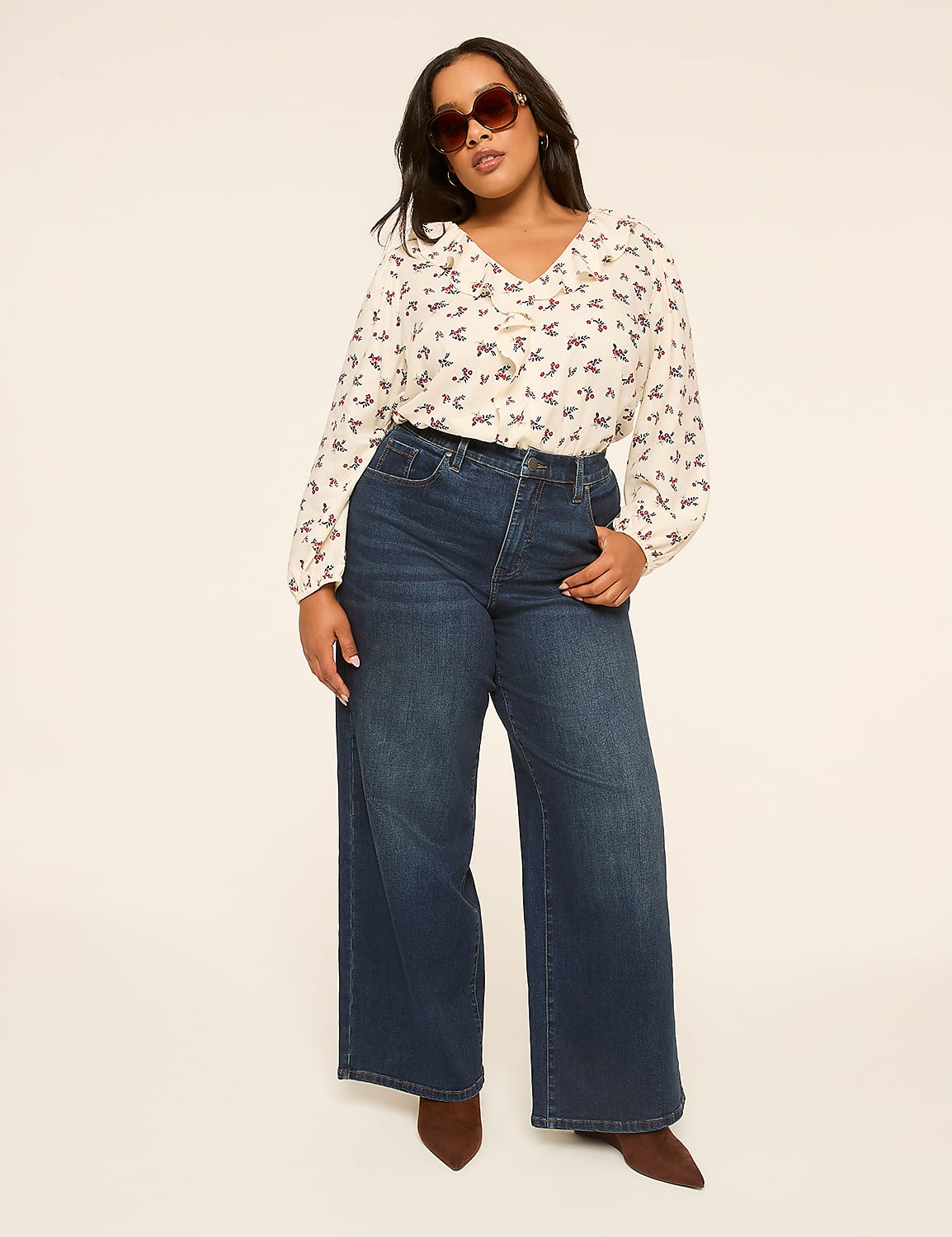 A woman in a patterned blouse and wide-leg jeans stands against a plain, light-colored background. Product Image 3