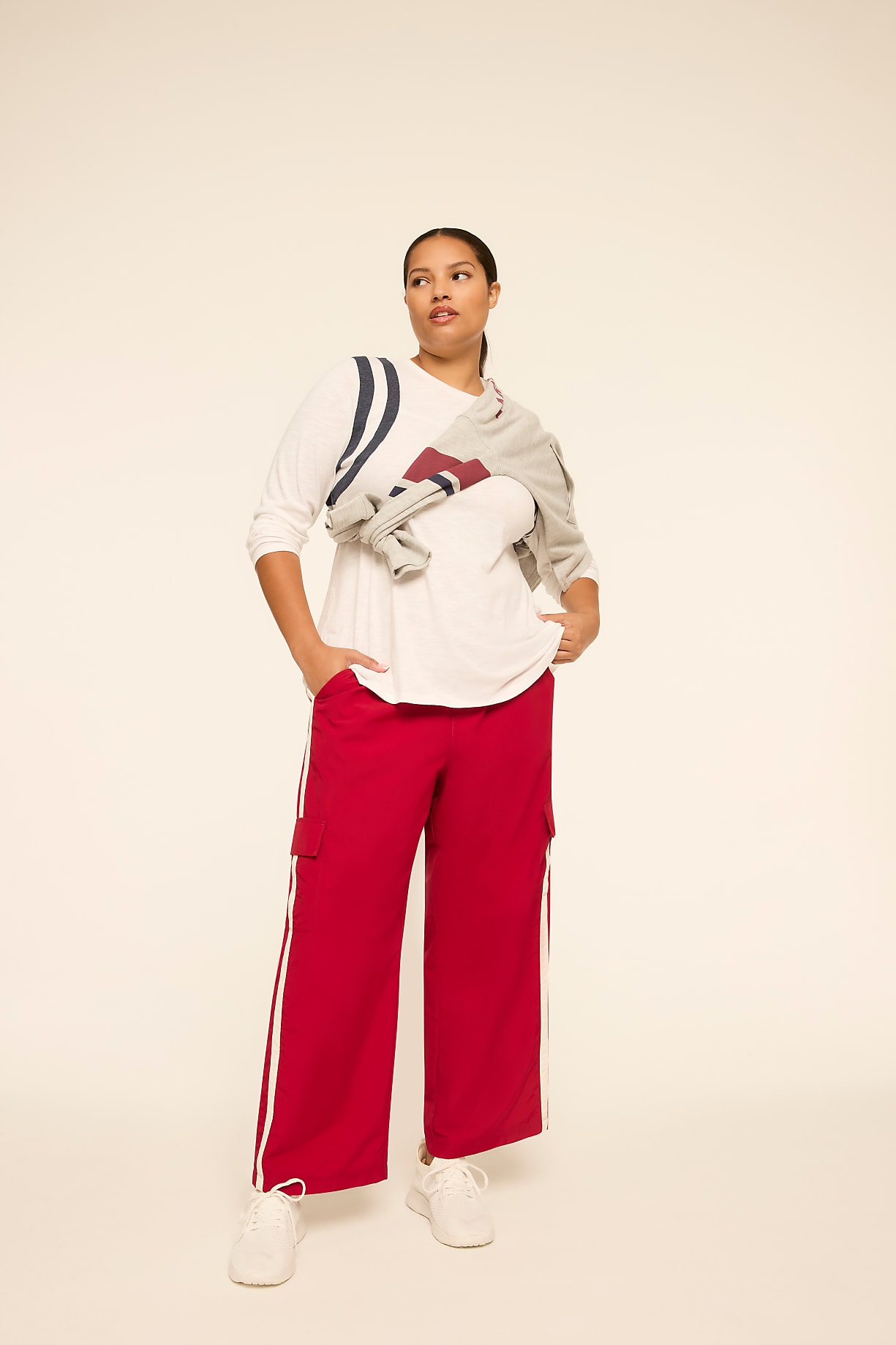 A woman in red cargo pants and a white long-sleeved shirt stands against a plain, light-colored background. Product Image 4