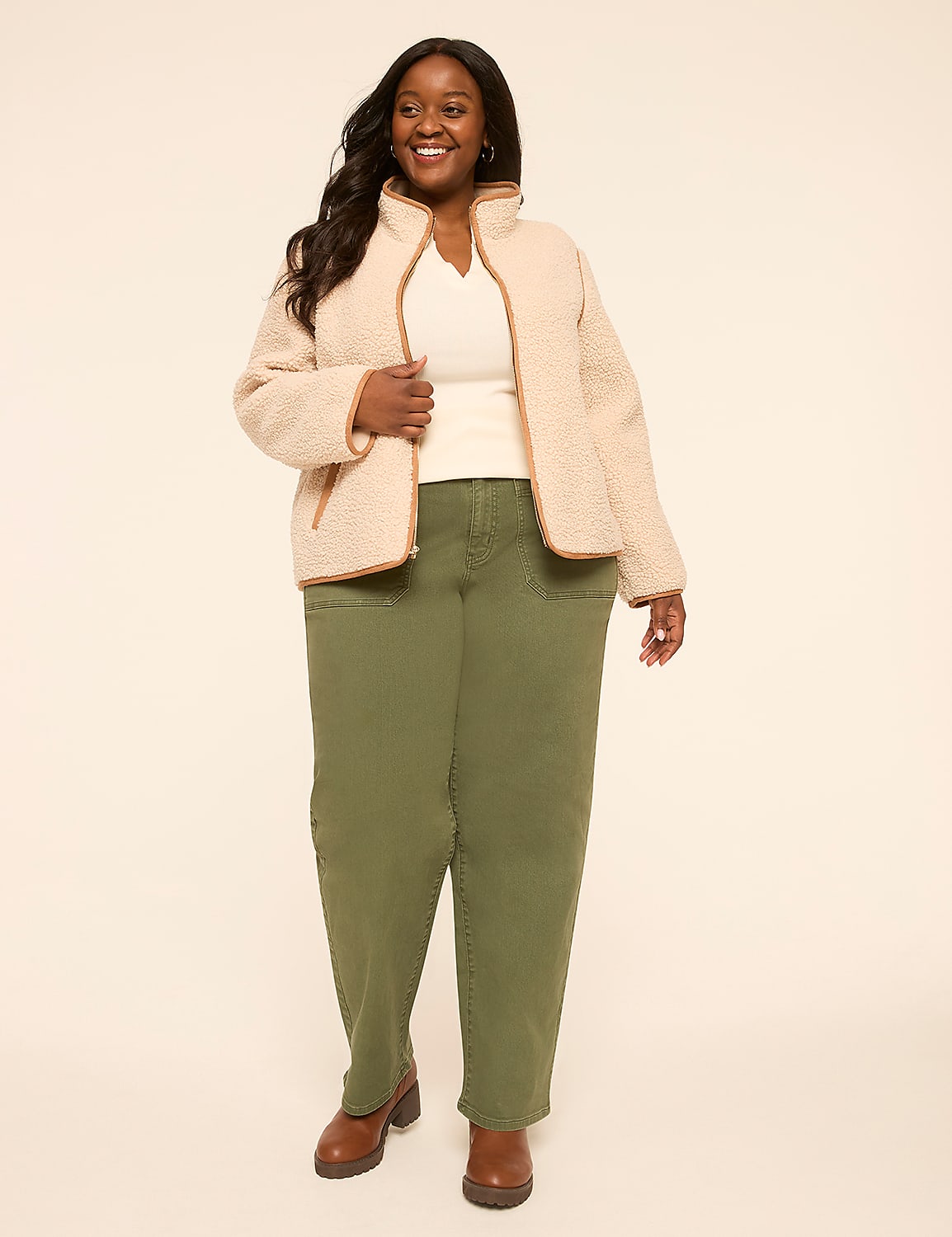 A smiling woman in a cream fleece jacket and olive green pants stands against a plain, light background. Product Image 3