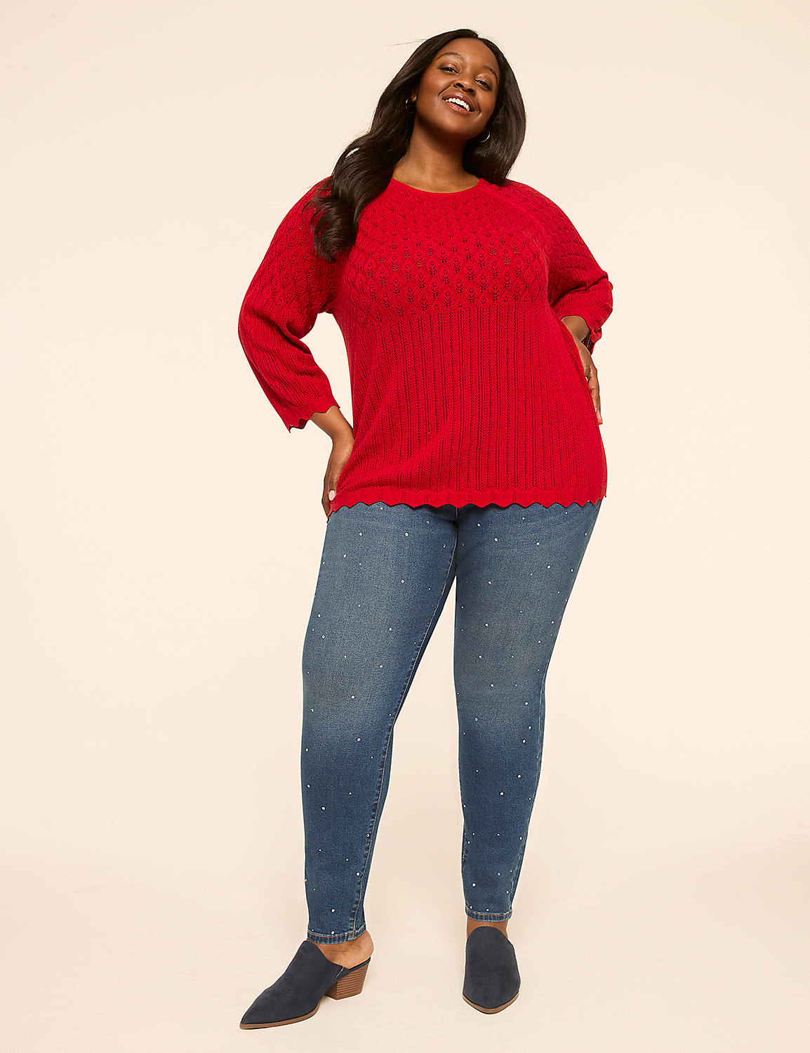 A smiling woman in a red sweater and jeweled jeans stands against a plain, light-colored background. Product Image 3