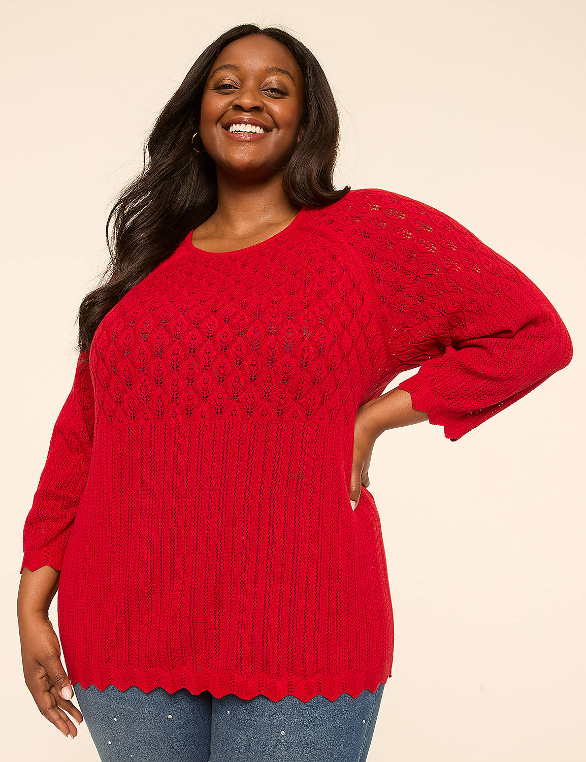 A smiling woman in a red sweater stands against a plain, light-colored background. Product Image 1