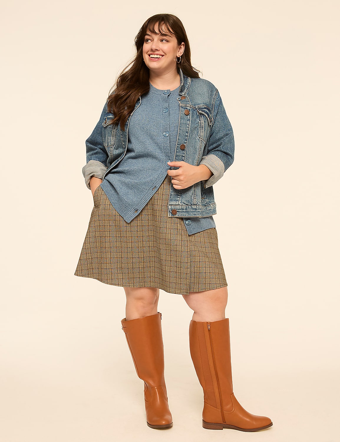 A smiling woman in a denim jacket, plaid skirt, and brown boots stands against a plain, light-colored background. Product Image 3