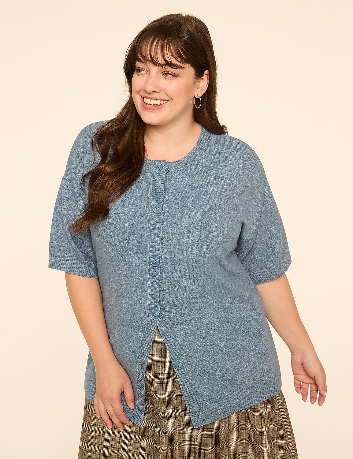 A smiling woman in a blue cardigan and plaid skirt stands against a plain, light-colored background. Product Image 1