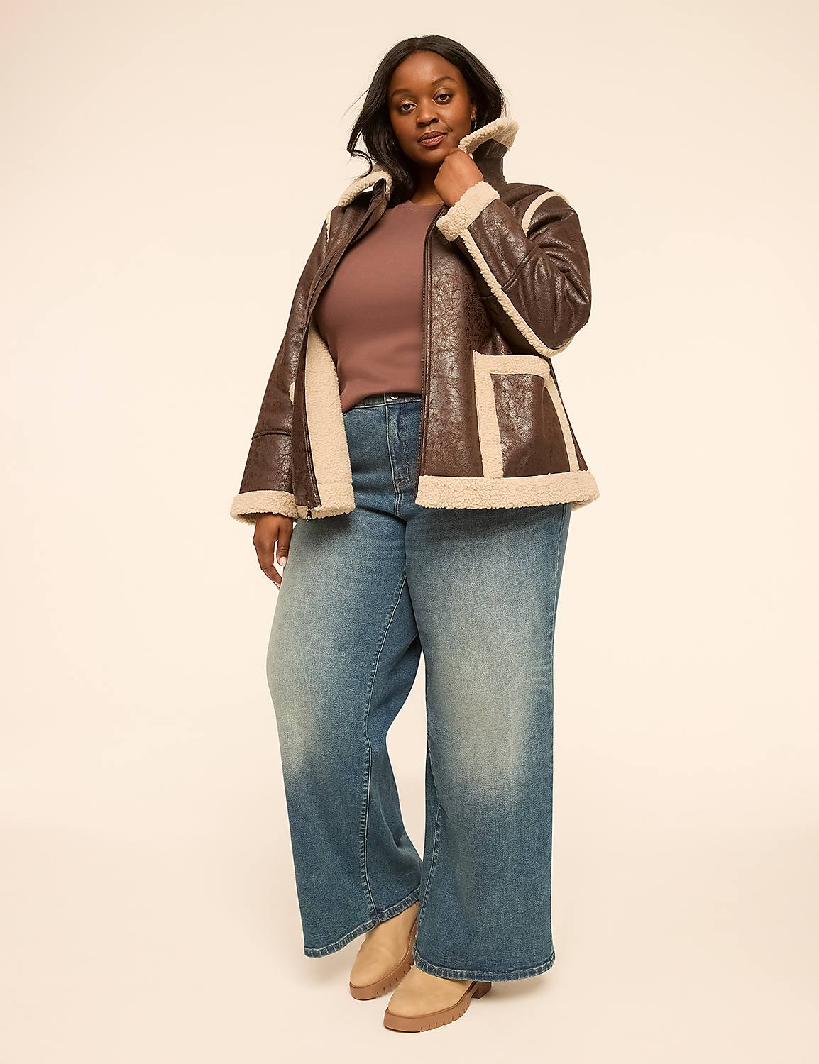 A woman in a brown faux fur-lined jacket and wide-leg jeans stands against a plain, light-colored background. Product Image 3