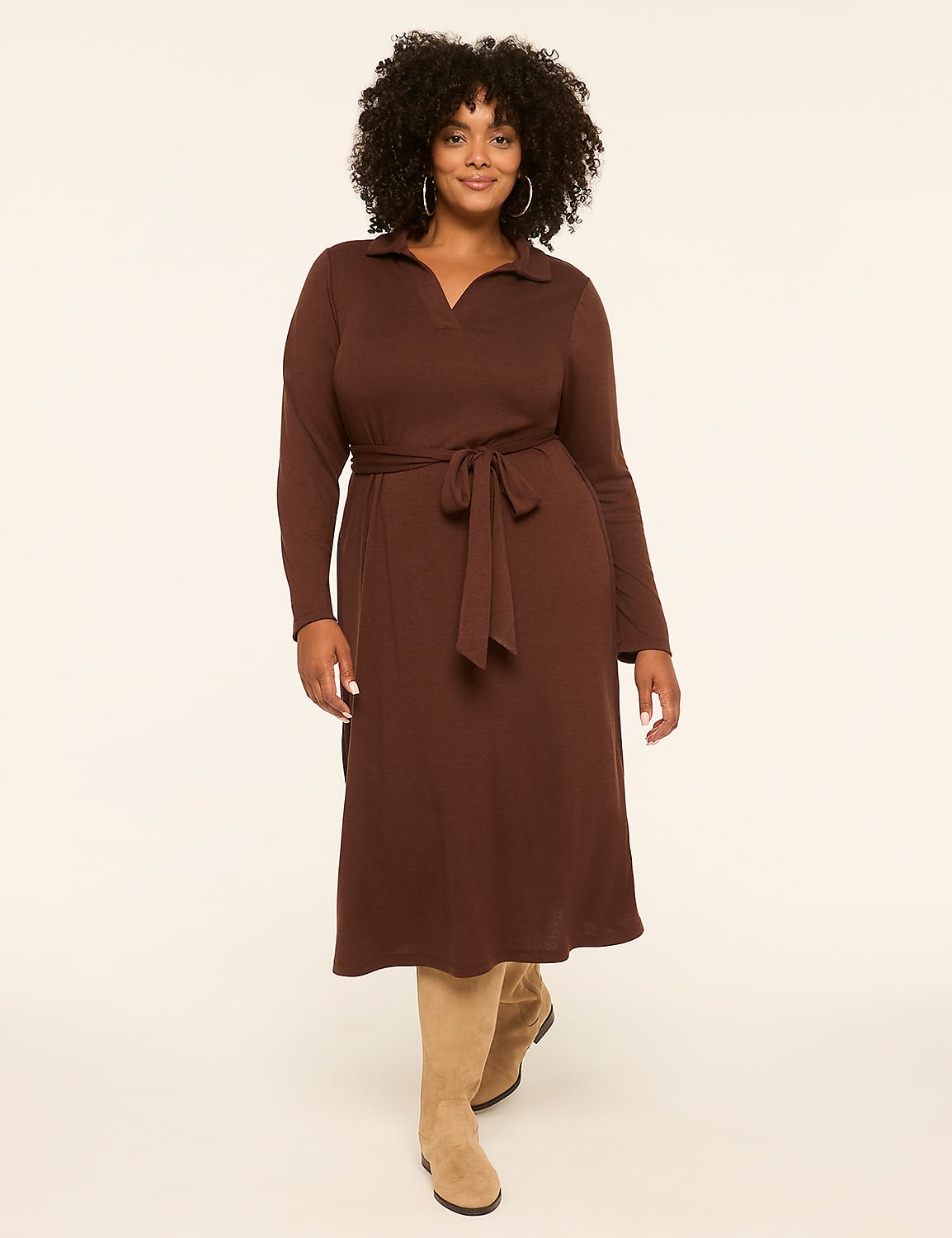 A woman in a brown dress and boots stands against a plain, light-colored background. Product Image 1