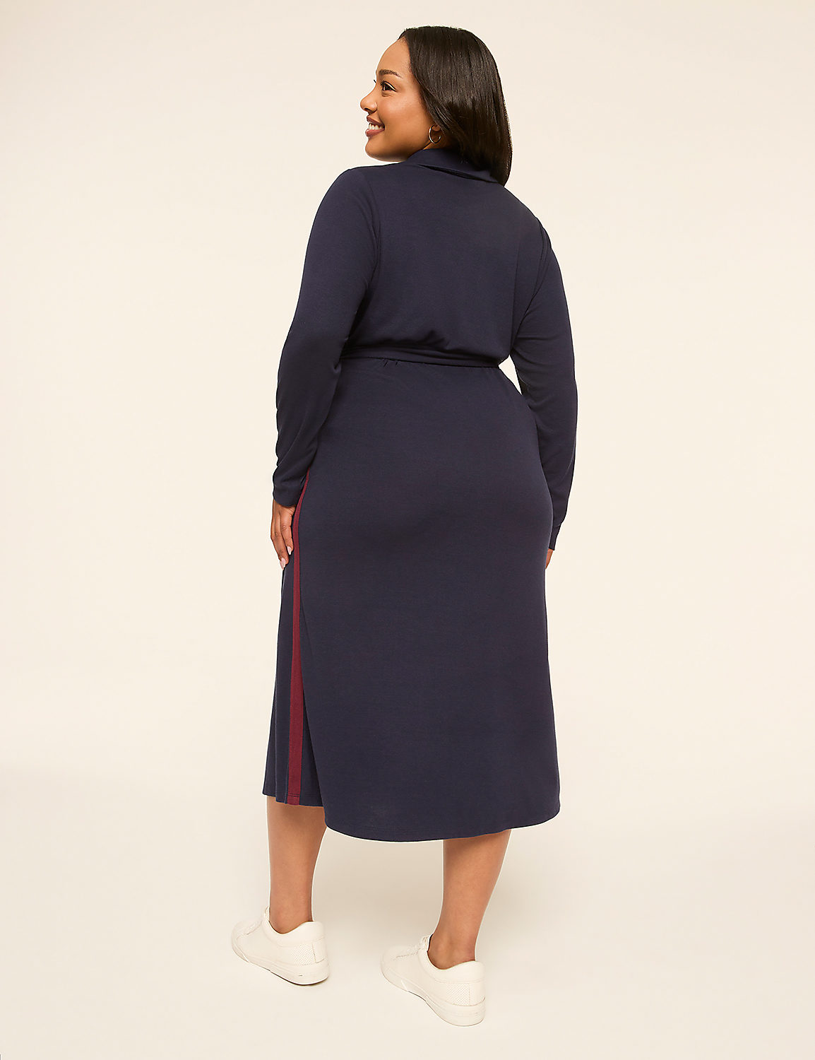 A woman in a navy blue dress with white sneakers stands against a plain, light-colored background. Product Image 2