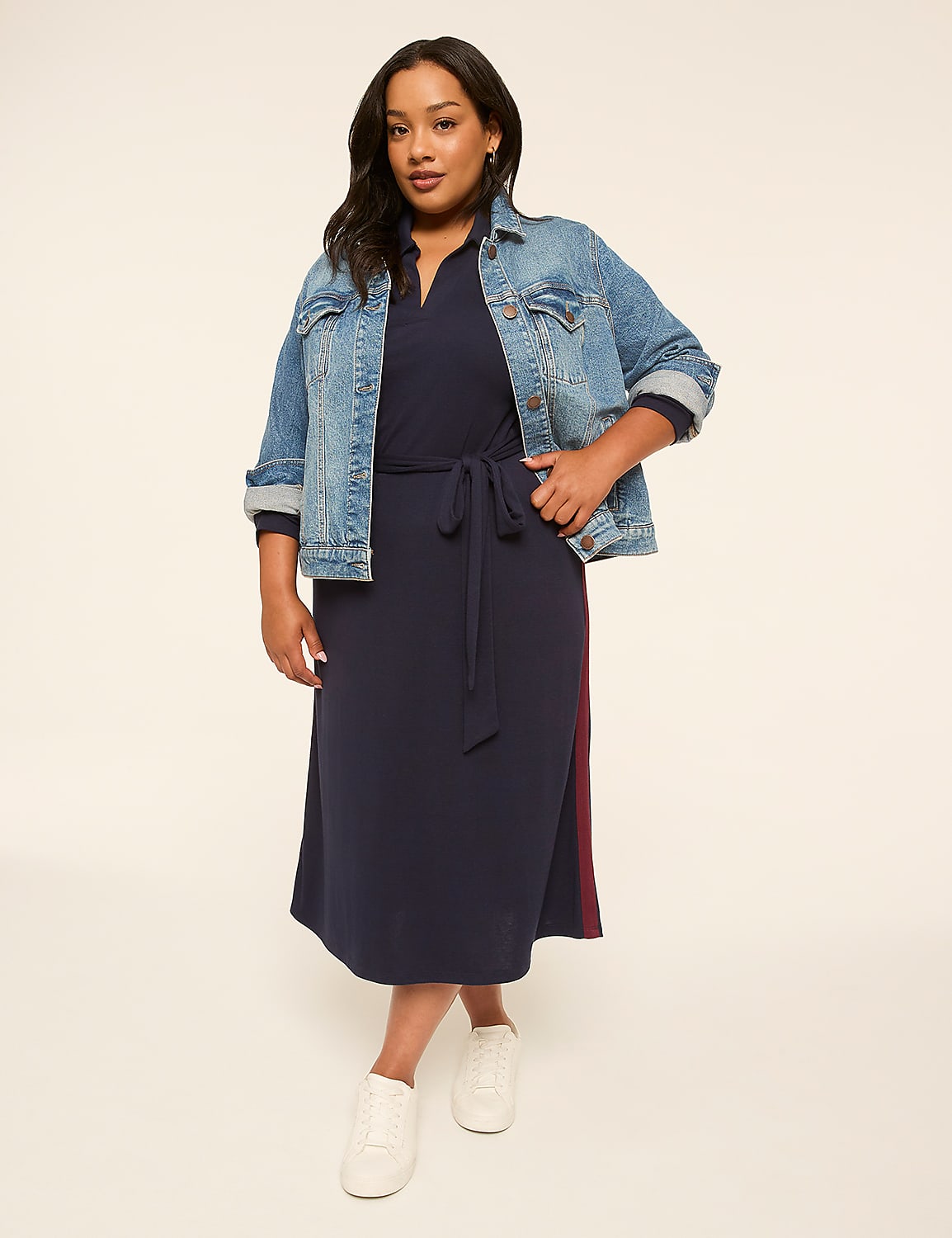 A woman in a navy dress and denim jacket stands against a plain, light background. Product Image 4