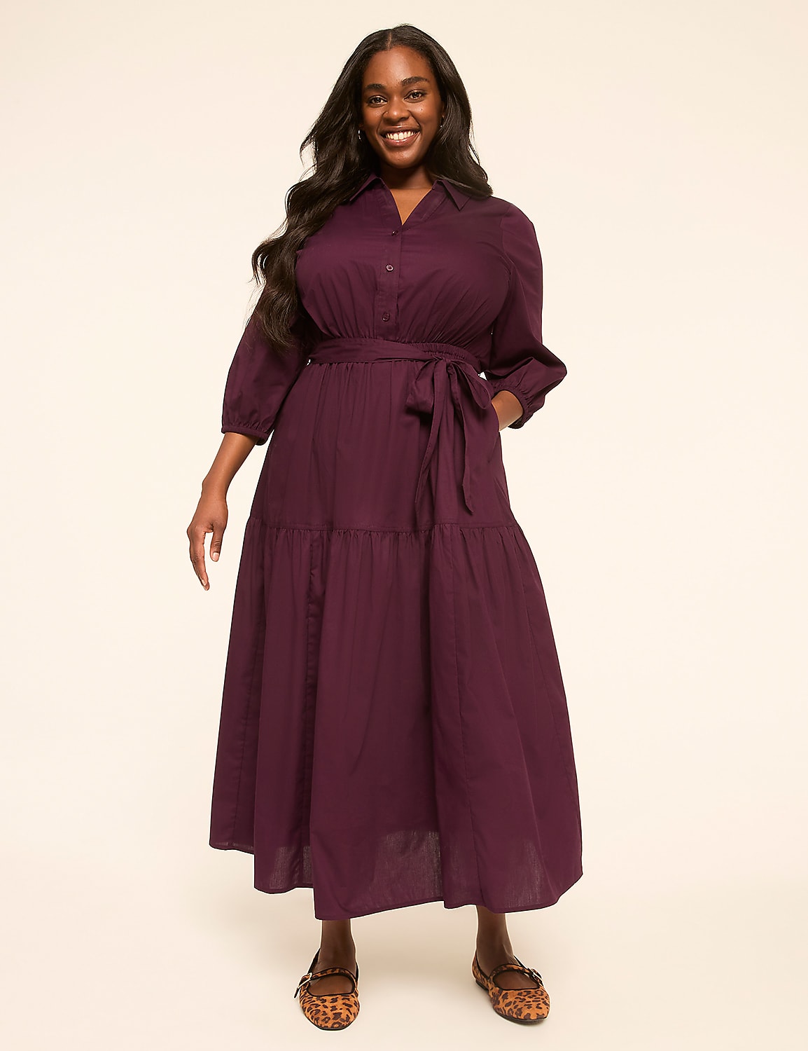 A smiling woman in a plum-colored tiered dress stands against a plain, light-colored background. Product Image 1