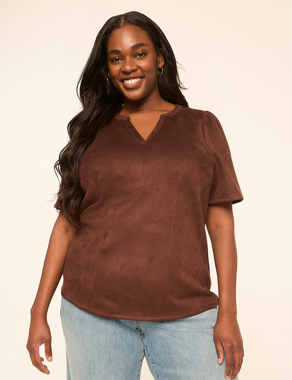 A smiling woman with long dark hair wears a brown suede top and light blue jeans against a plain, light-colored background. Product Image 1