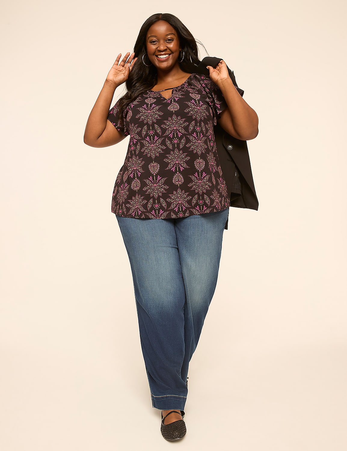 A smiling woman in a patterned top and wide-leg jeans stands against a plain, light-colored background. Product Image 3