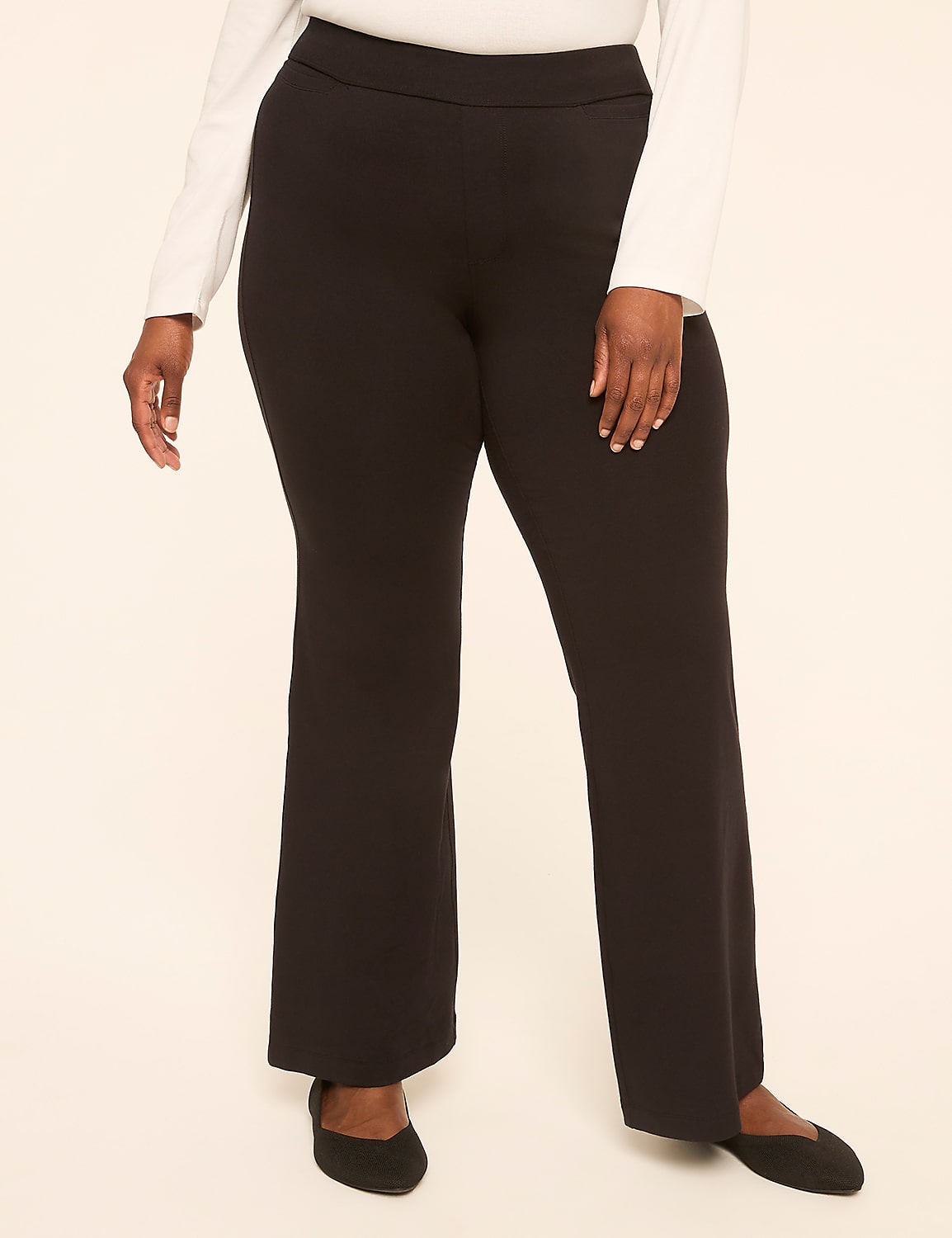 A person wearing black flared pants and black flats stands against a plain, light-colored background. Product Image 1