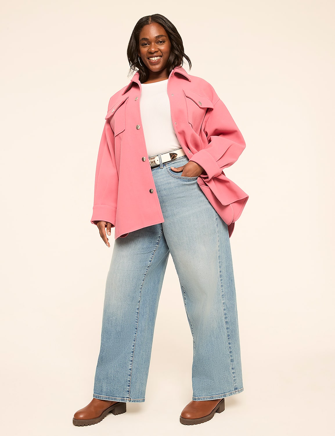 A smiling woman in a pink jacket and wide-leg jeans stands against a plain, light-colored background. Product Image 3