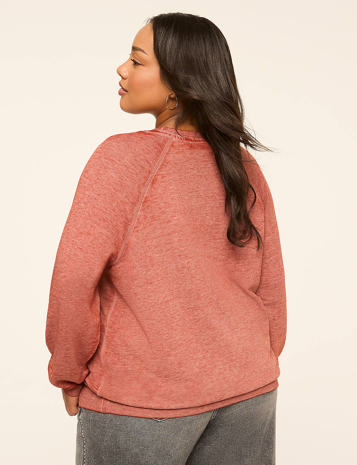 A woman in a rust-colored sweatshirt and gray jeans stands against a plain, light-colored background. Product Image 2