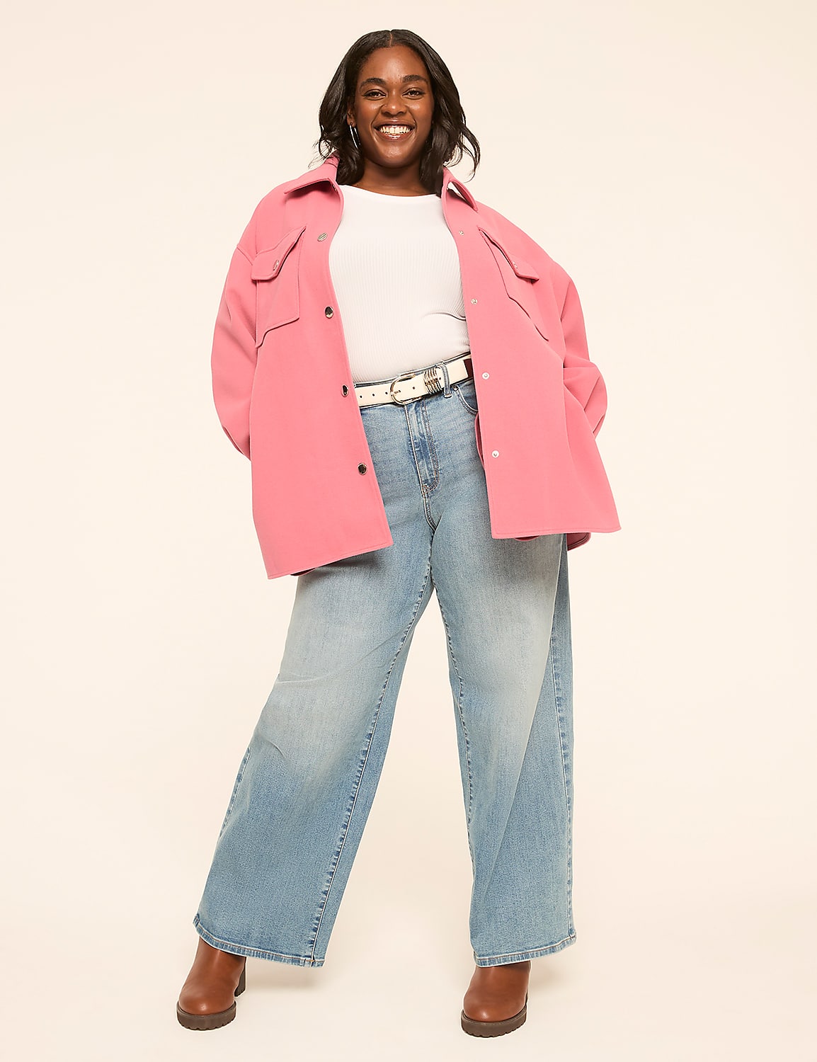 A smiling woman in a pink jacket and wide-leg jeans stands against a plain, light-colored background. Product Image 3