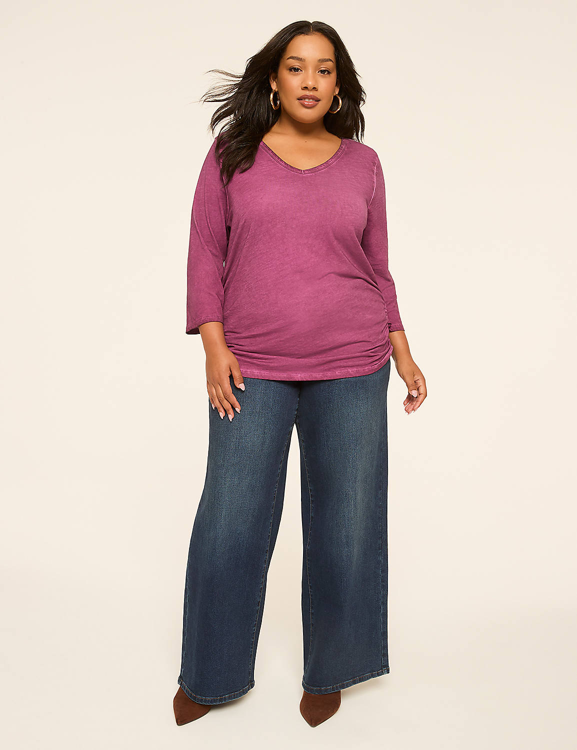 A woman in a purple top and wide-leg jeans stands against a plain, light-colored background. Product Image 3