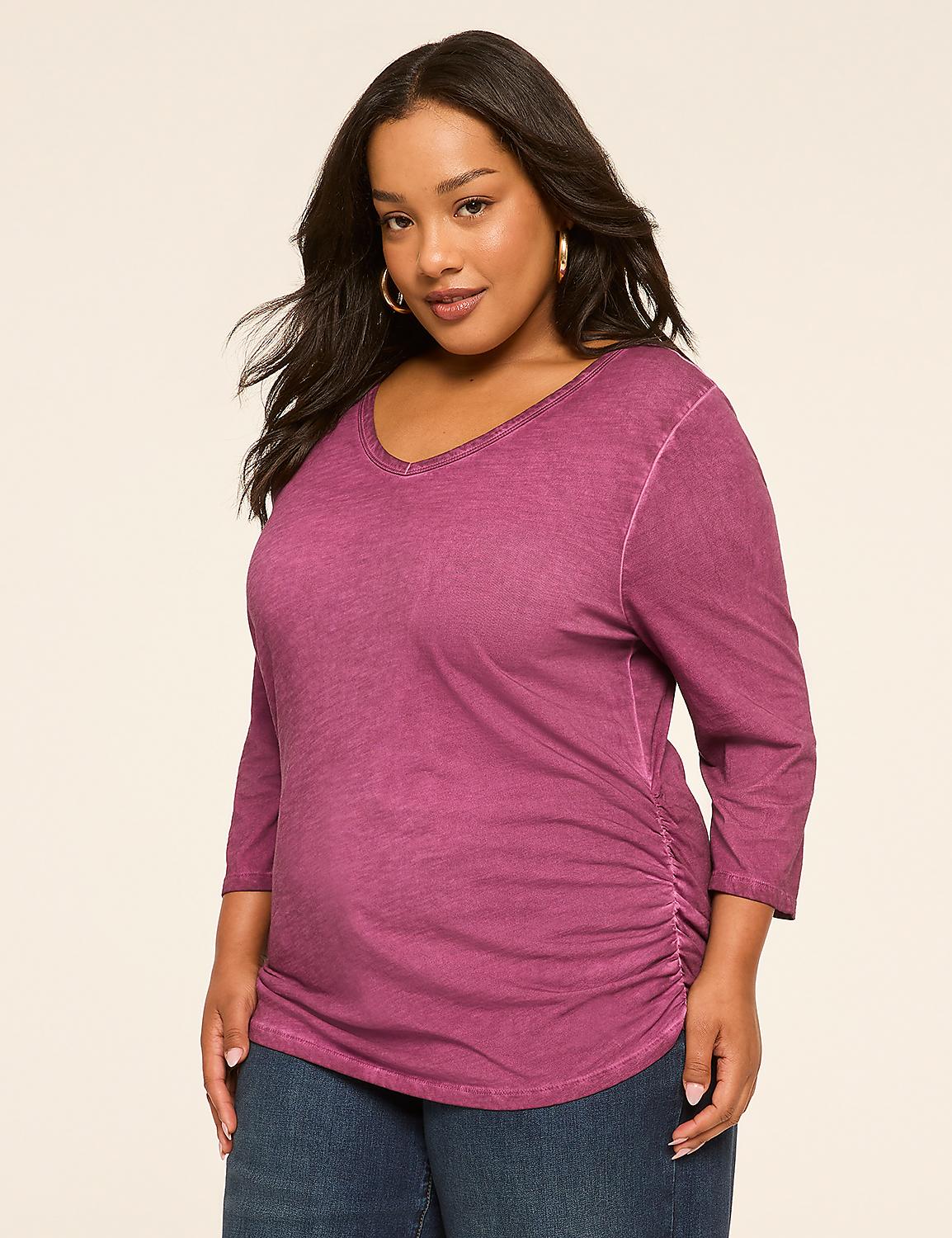 A woman in a purple, ruched, three-quarter sleeve top and blue jeans stands against a plain, light-colored background. Product Image 1