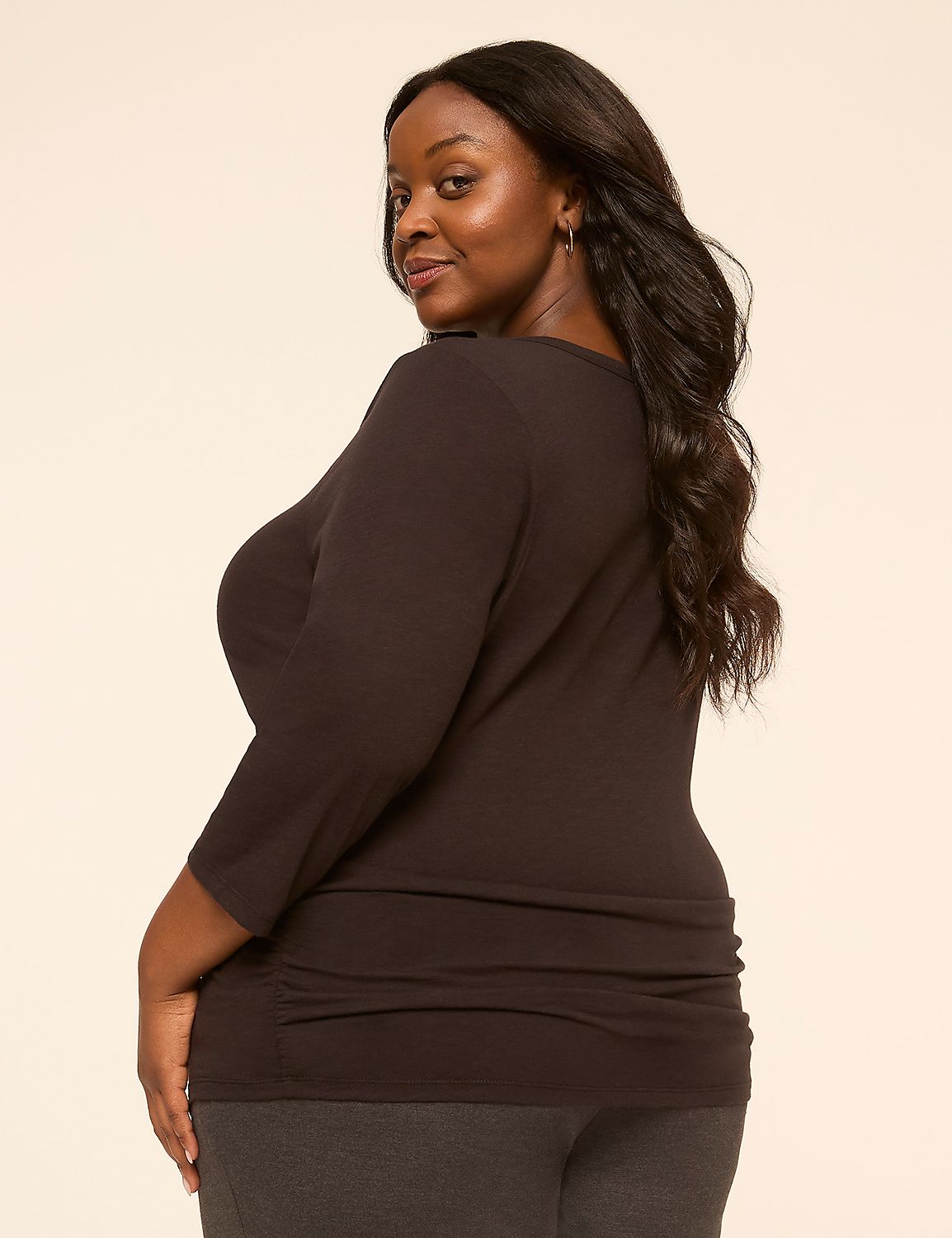 A woman with dark hair and a dark shirt is in the foreground, with a plain, light-colored background. Product Image 2