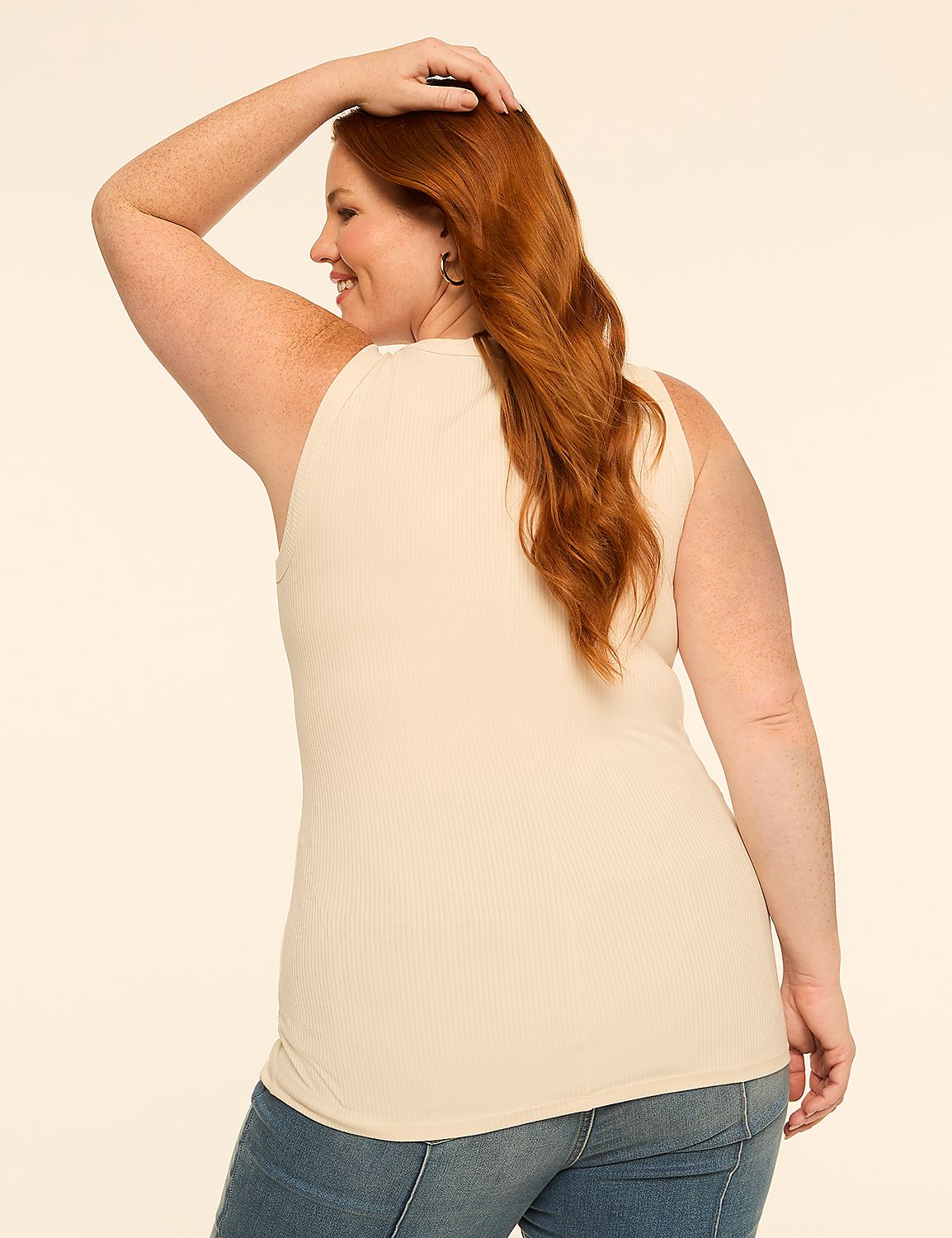 A woman with red hair in a cream-colored ribbed tank top and blue jeans poses against a plain, light-colored background. Product Image 2