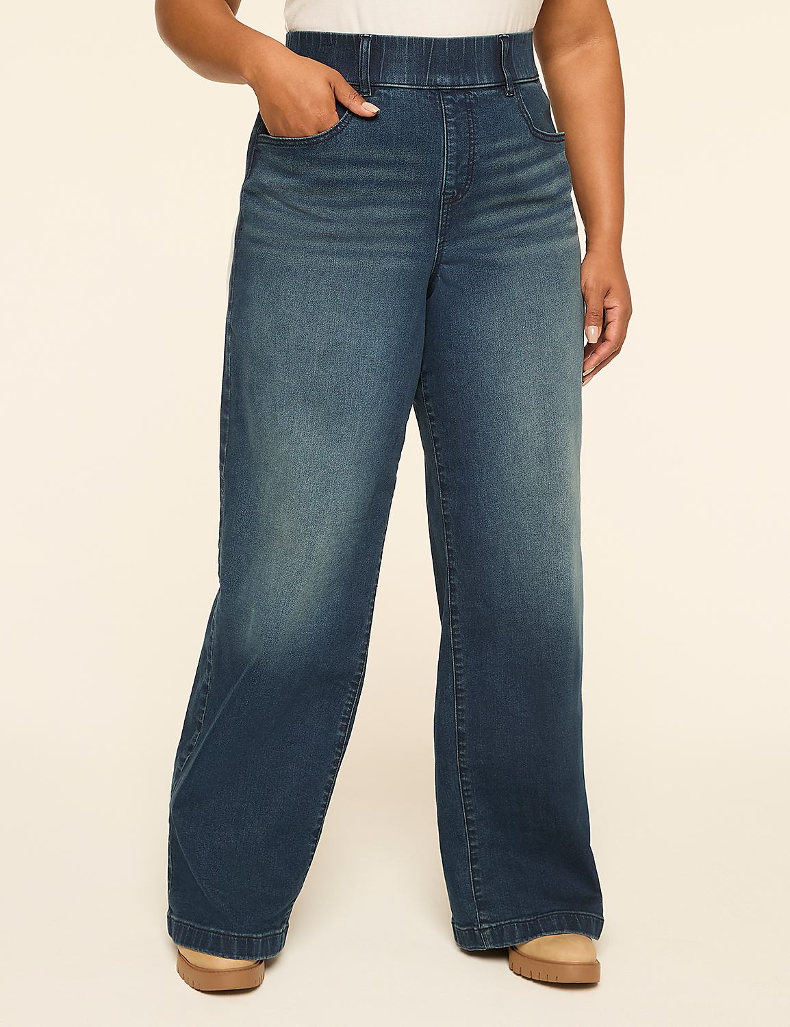 A person stands in wide-leg denim jeans with a hand in their pocket, against a plain, light-colored background. Product Image 1