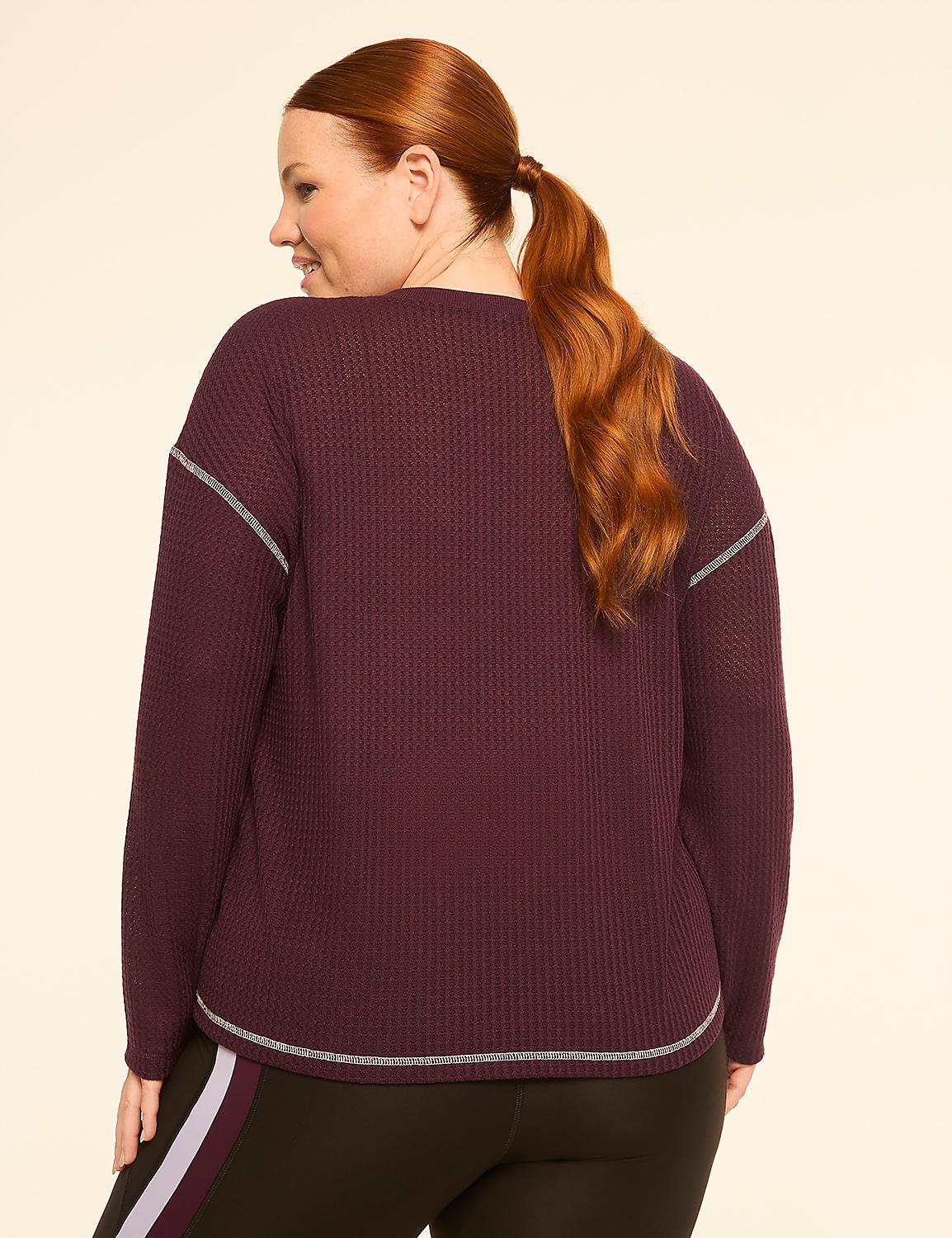 A woman with auburn hair pulled into a ponytail, wearing a burgundy waffle-knit top and black leggings with a purple stripe, stands against a plain cream background. Product Image 2