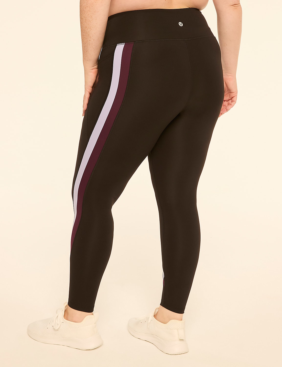 A person wearing black leggings with purple and lavender stripes stands against a plain, light-colored background. Product Image 2