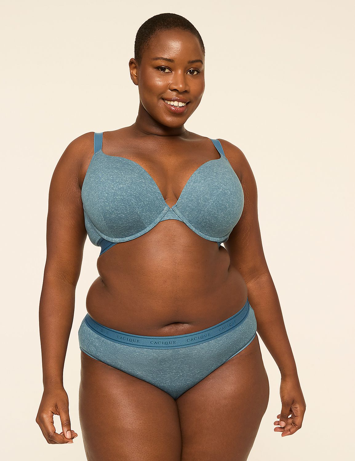 A smiling woman with dark skin and short hair poses in a blue bra and matching underwear against a plain, light-colored background. Product Image 4