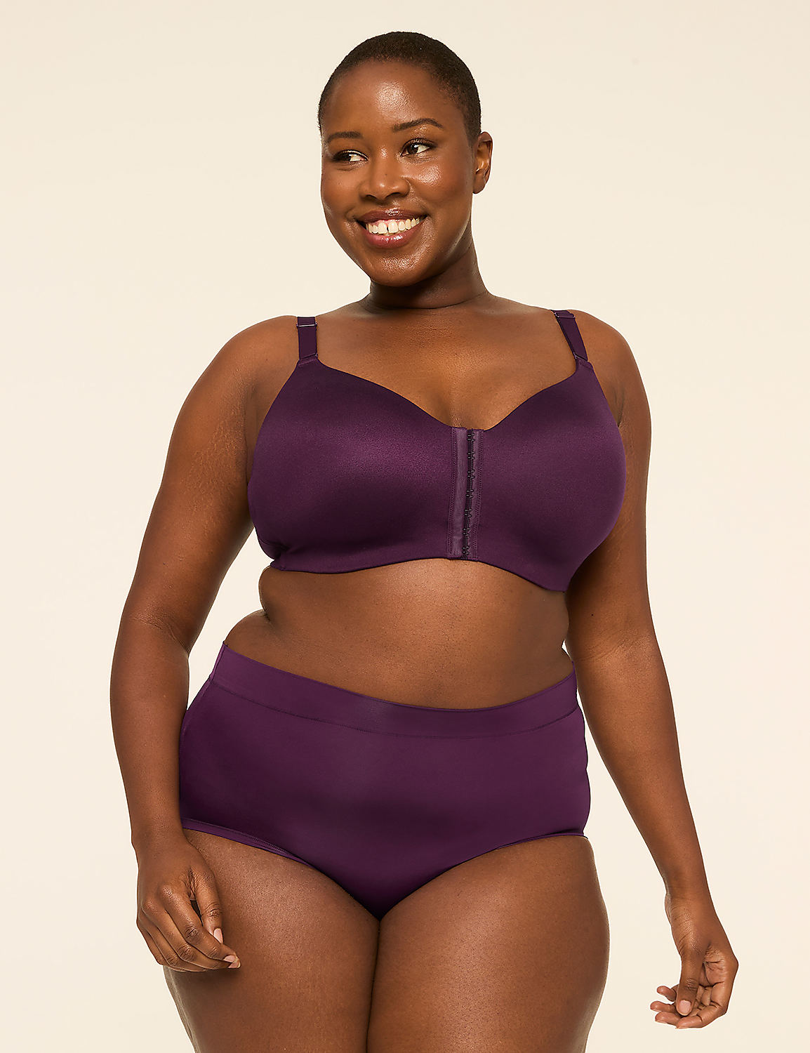 A smiling woman in a purple bra and matching underwear stands against a plain, light-colored background. Product Image 4