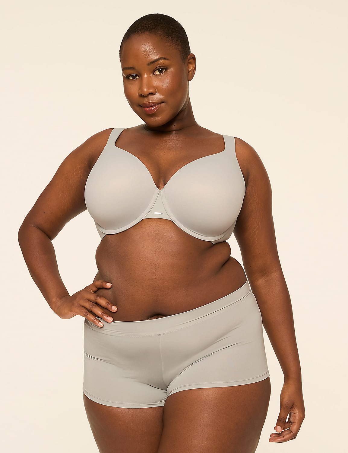 A woman with dark skin and short hair poses in a light gray bra and matching boy shorts against a plain, light background. Product Image 4