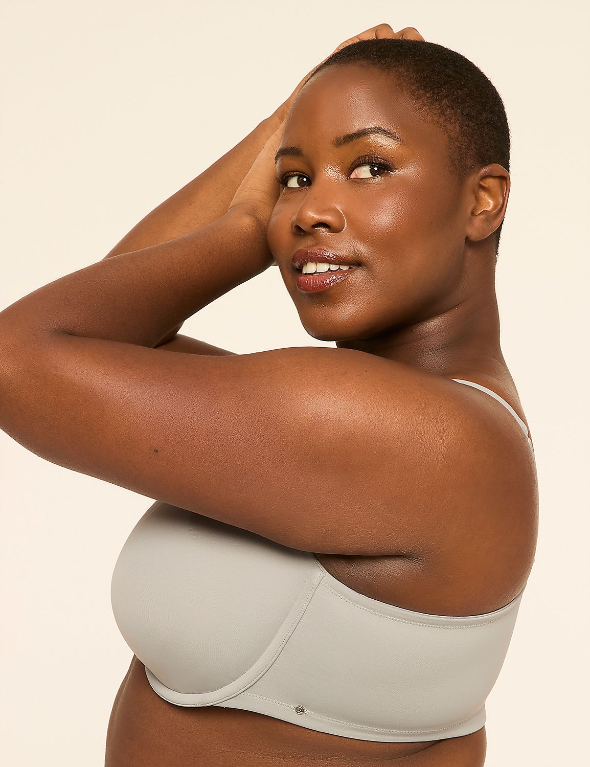 A woman with short hair and a light gray bra poses with her arms behind her head against a plain, light background. Product Image 3