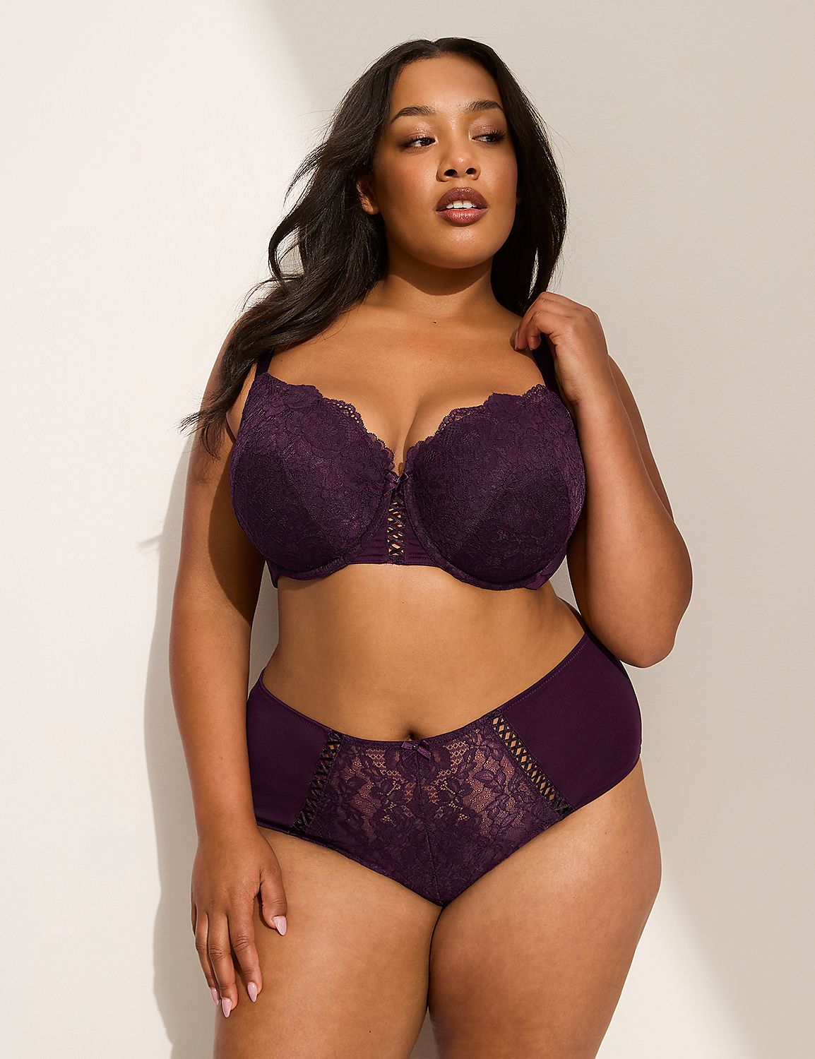 A woman in a purple lace bra and matching underwear stands against a plain white background with soft lighting. Product Image 4