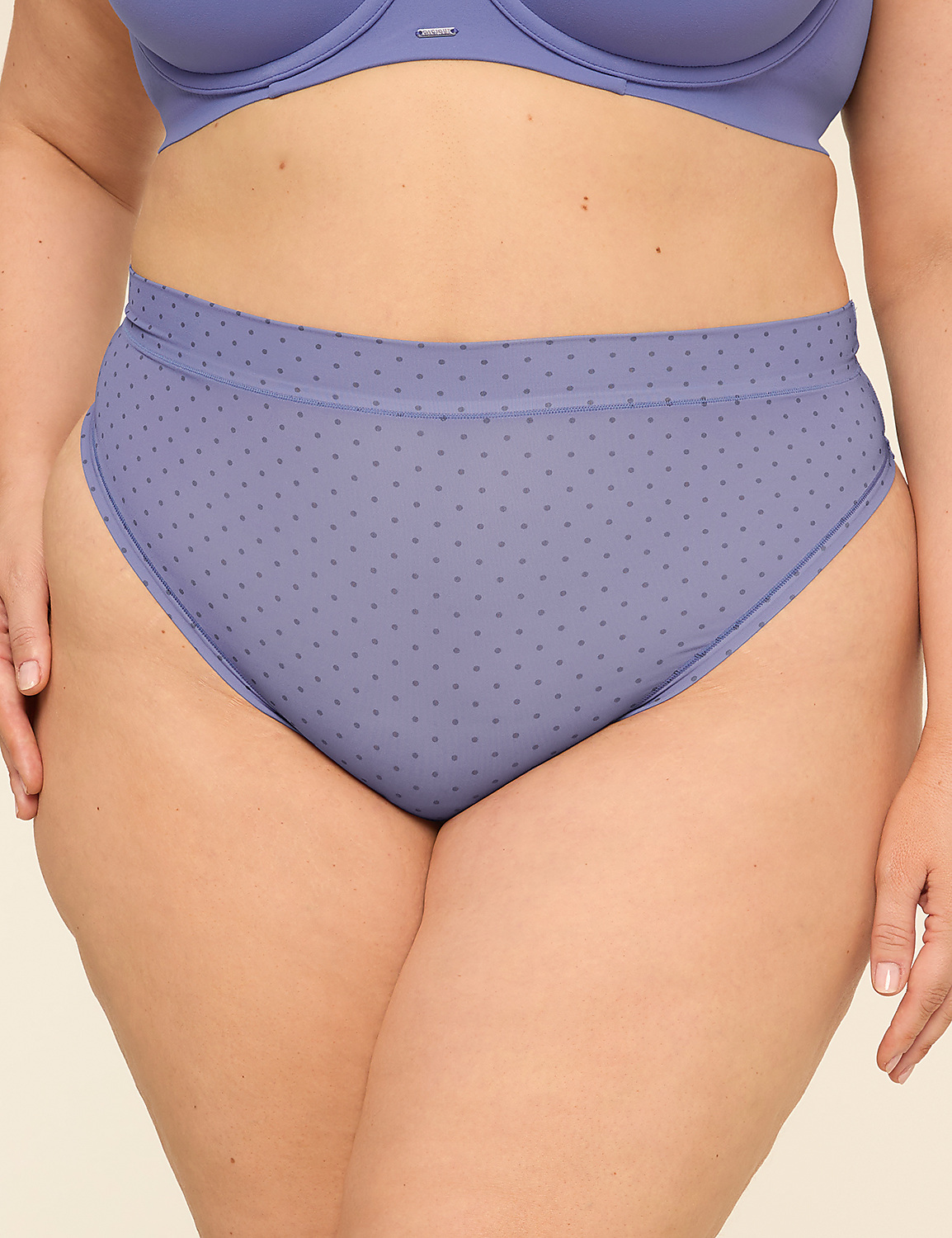 A person's lower torso is shown wearing a blue polka dot high-waisted brief and a matching bra, against a plain background. Product Image 1