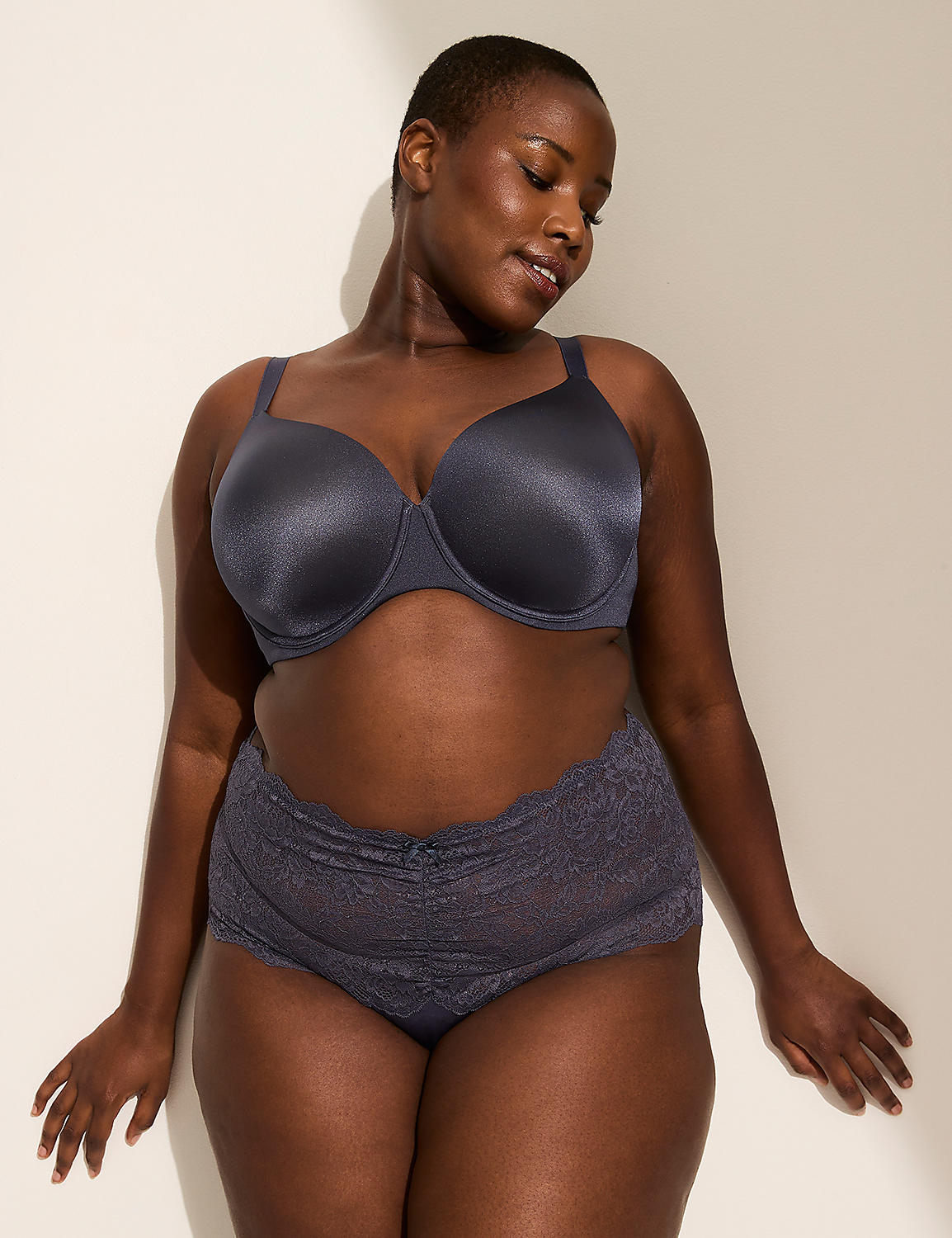A woman in a gray bra and lace underwear stands against a plain, light-colored wall with soft lighting. Product Image 4