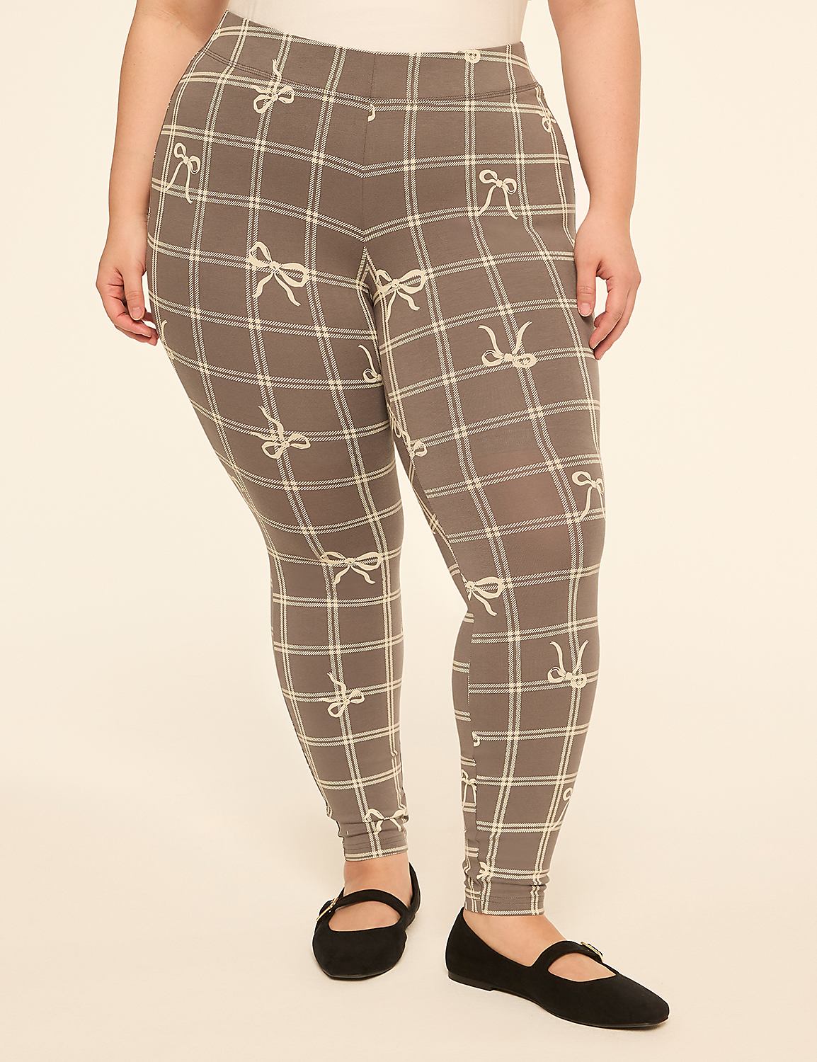 A person wearing grey plaid leggings with a bow pattern stands against a plain, light-colored background. Product Image 1
